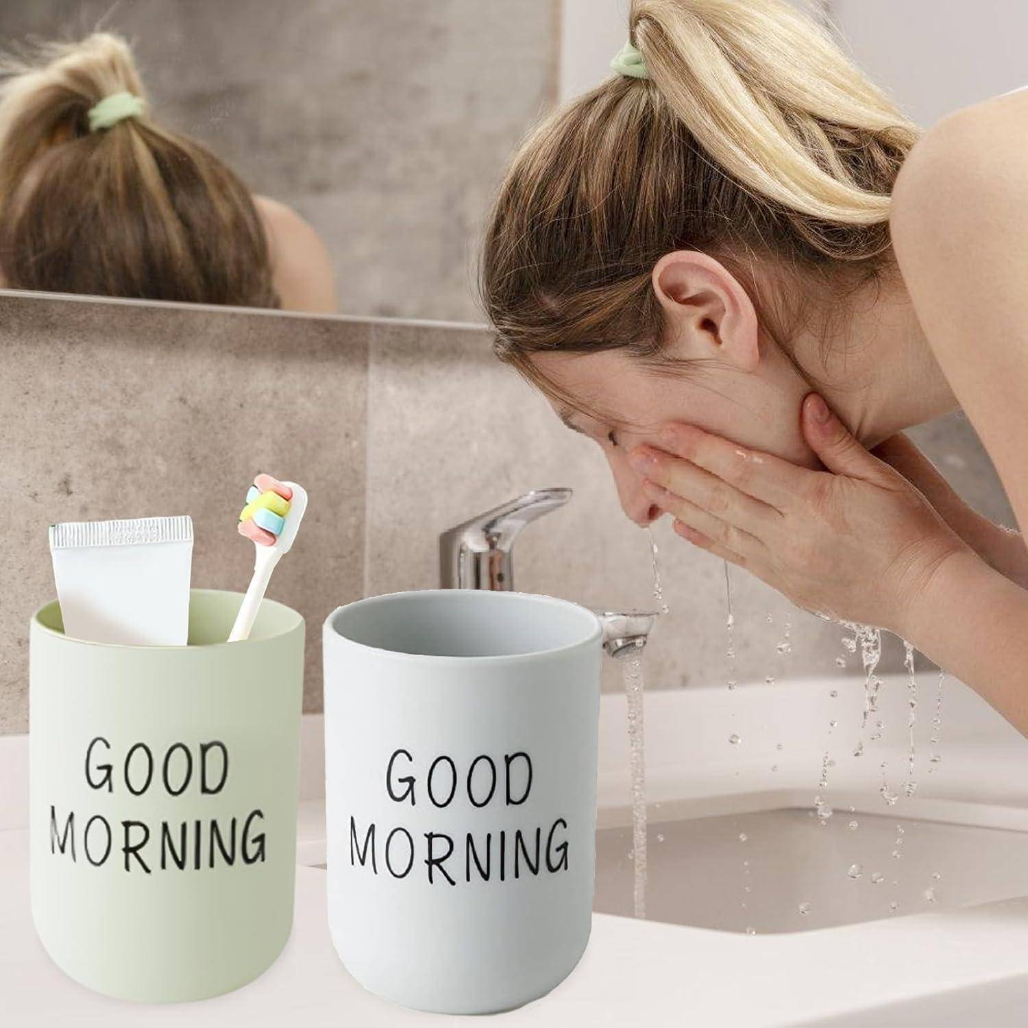 Frau, die ihr Gesicht an einem Waschbecken im Badezimmer neben zwei „GUTEN MORGEN