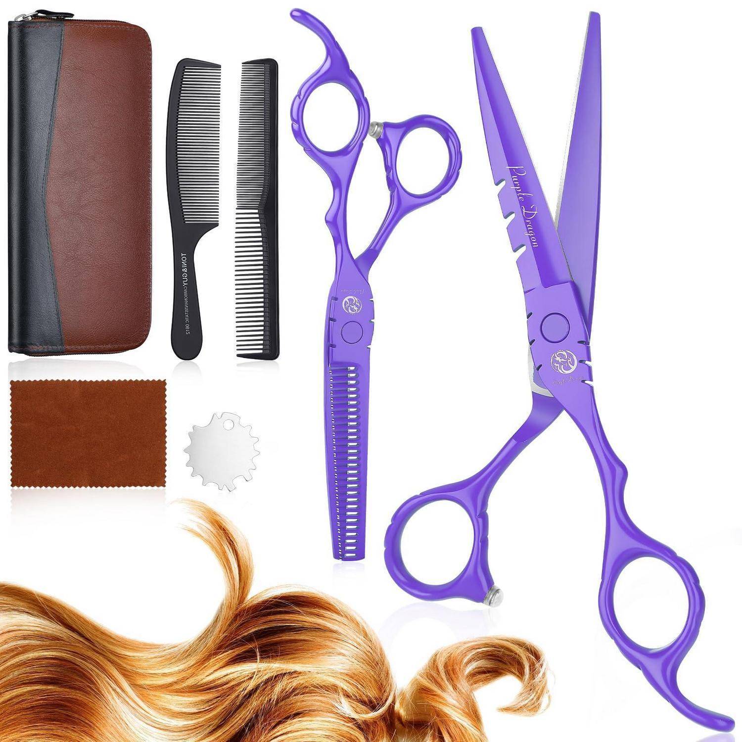 Haarschneideset mit violetten Scheren und Effilierscheren, Kämmen, Rasiermesser, Etui, Tuch und einer Strähne gestylter Haare auf weißem Hintergrund.