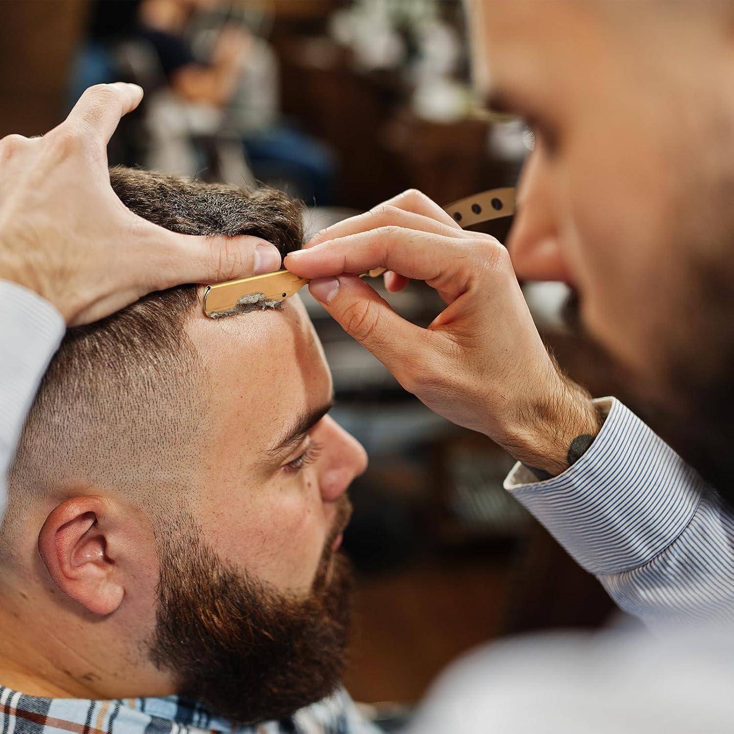 Der Friseur rasiert die Haaransatzlinie eines bärtigen Mannes mit einem Rasiermesser, während er den Kopf ruhig hält.