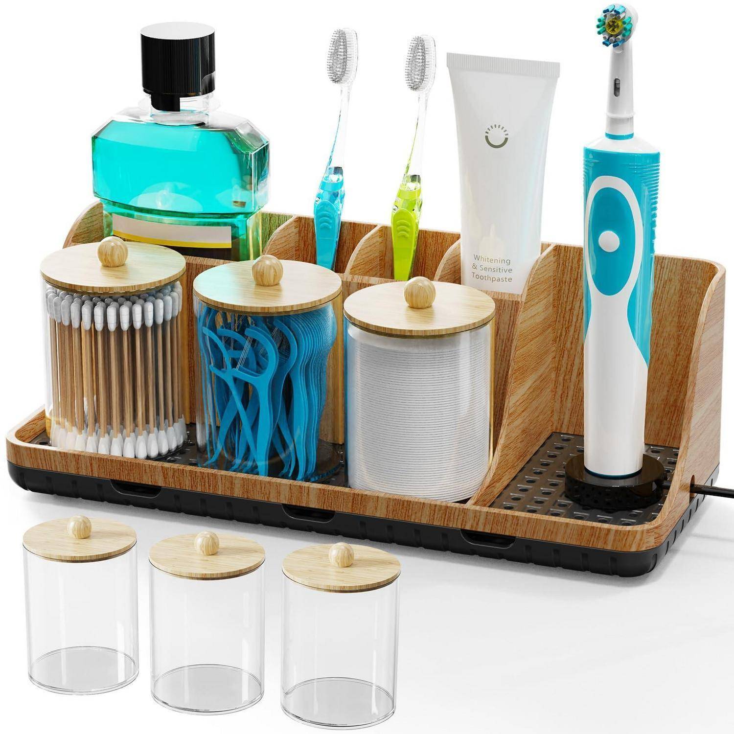 Badezimmer-Arbeitsplatte-Organizer mit Zahnbürstenhalter, zwei elektrischen Zahnbürsten, Zahnpastatube, Mundwasserflasche und drei durchsichtigen Lagerbehältern mit Bambusdeckeln.