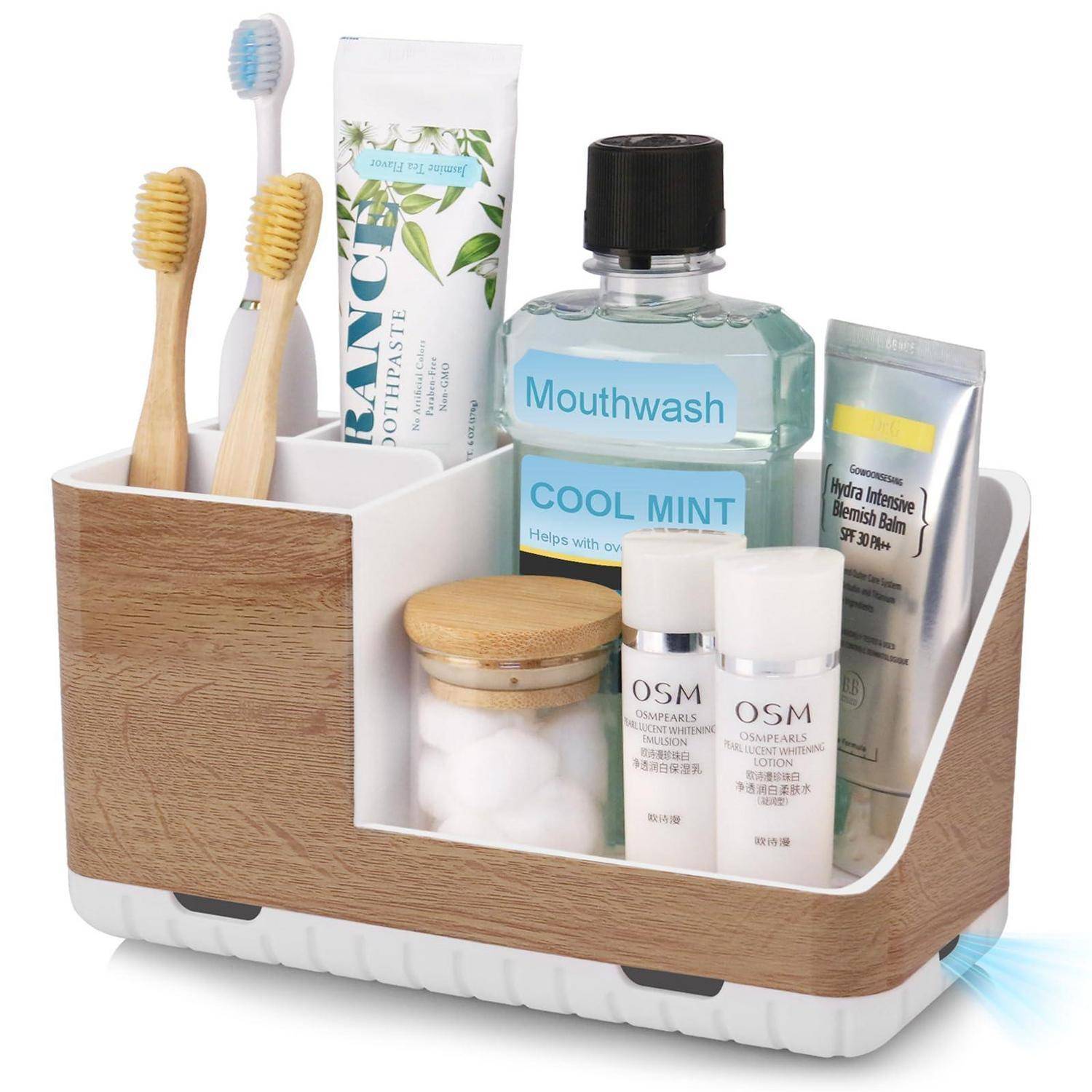 Badezimmer-Arbeitsplatte-Organizer mit Zahnbürsten, Zahnpasta, Mundwasser und Hautpflegeprodukten in unterteilten Fächern.