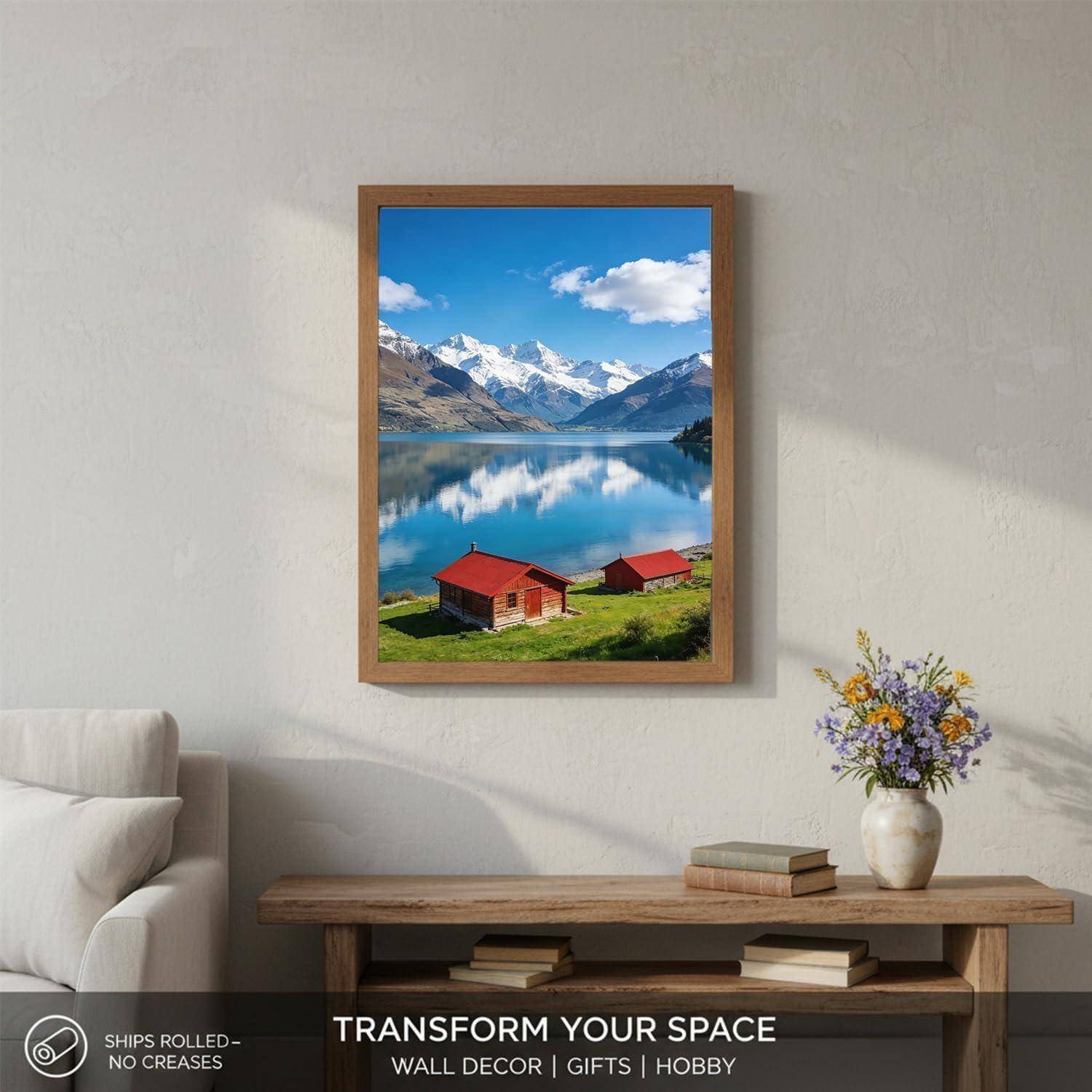 Gerahmter Landschaftsdruck über einem Konsolentisch zeigt einen See, Berge und rote Hütten; Wohnzimmerwanddekoration mit dem Text „TRANSFORM YOUR SPACE