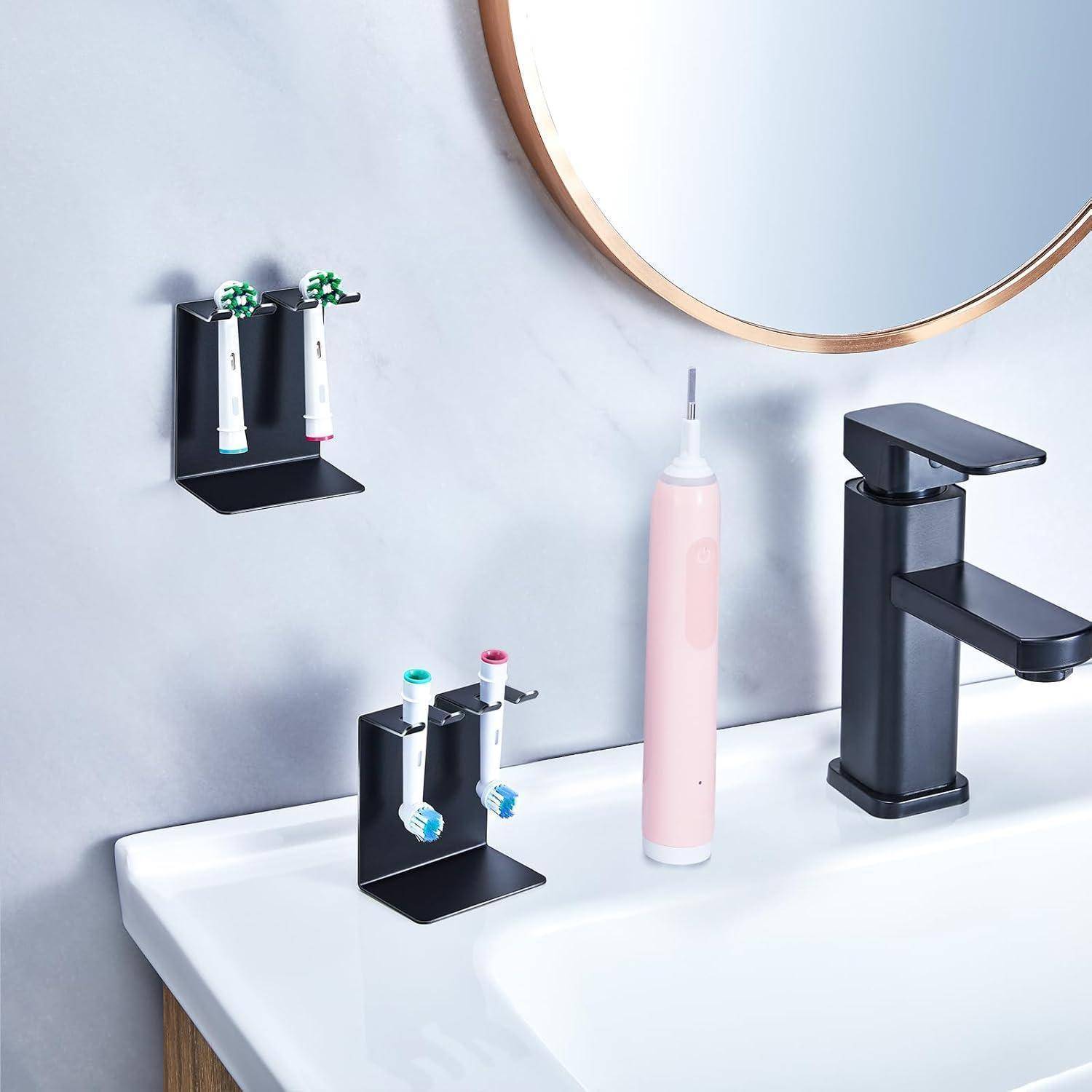 Badezimmerspüle mit schwarzer Wand und Waschtisch-Zahnbürstenhaltern, einer rosa elektrischen Zahnbürste und einem modernen schwarzen Wasserhahn neben einem runden Spiegel.