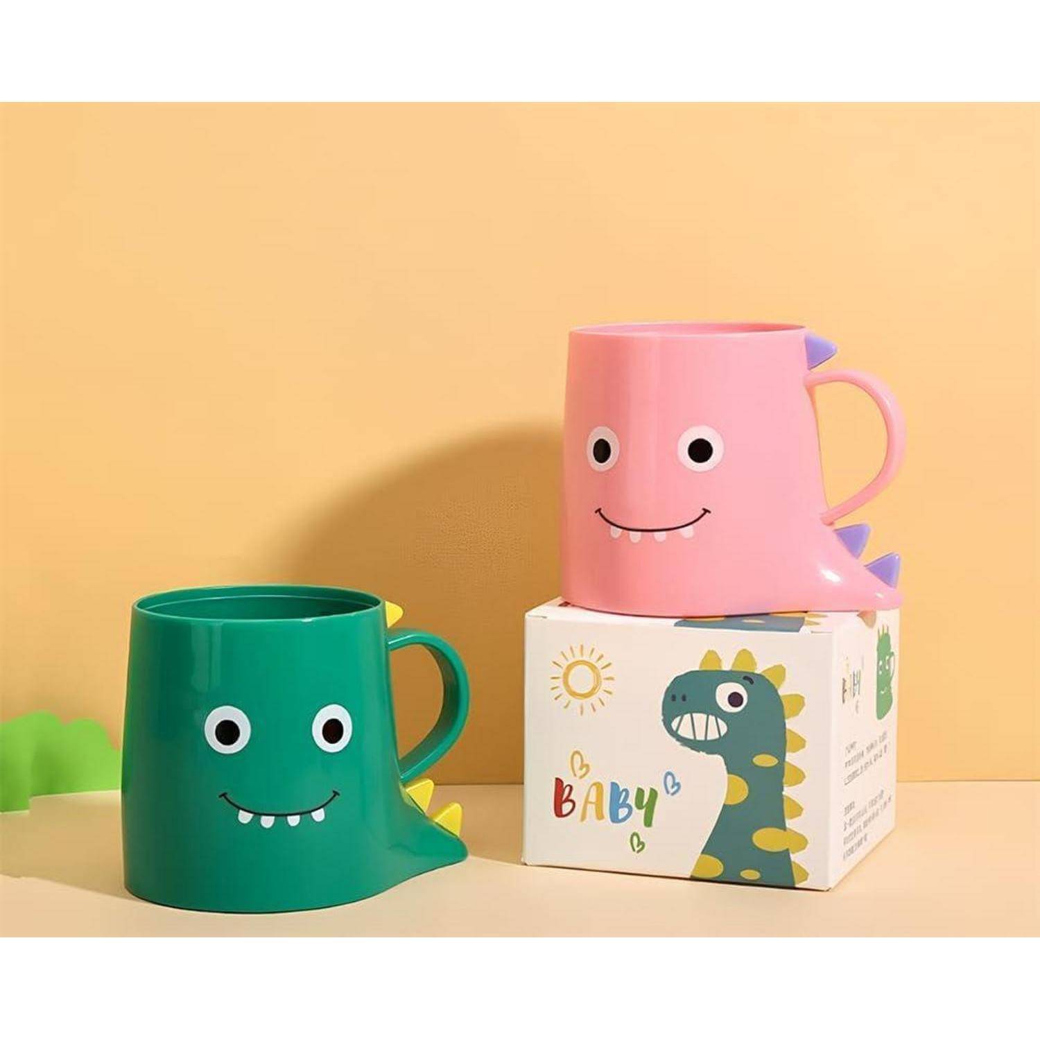 Zwei dinosaurierförmige Tassen, eine grüne und eine rosa, werden auf einer Schachtel mit babygerechter Dinosaurier-Verpackung präsentiert.