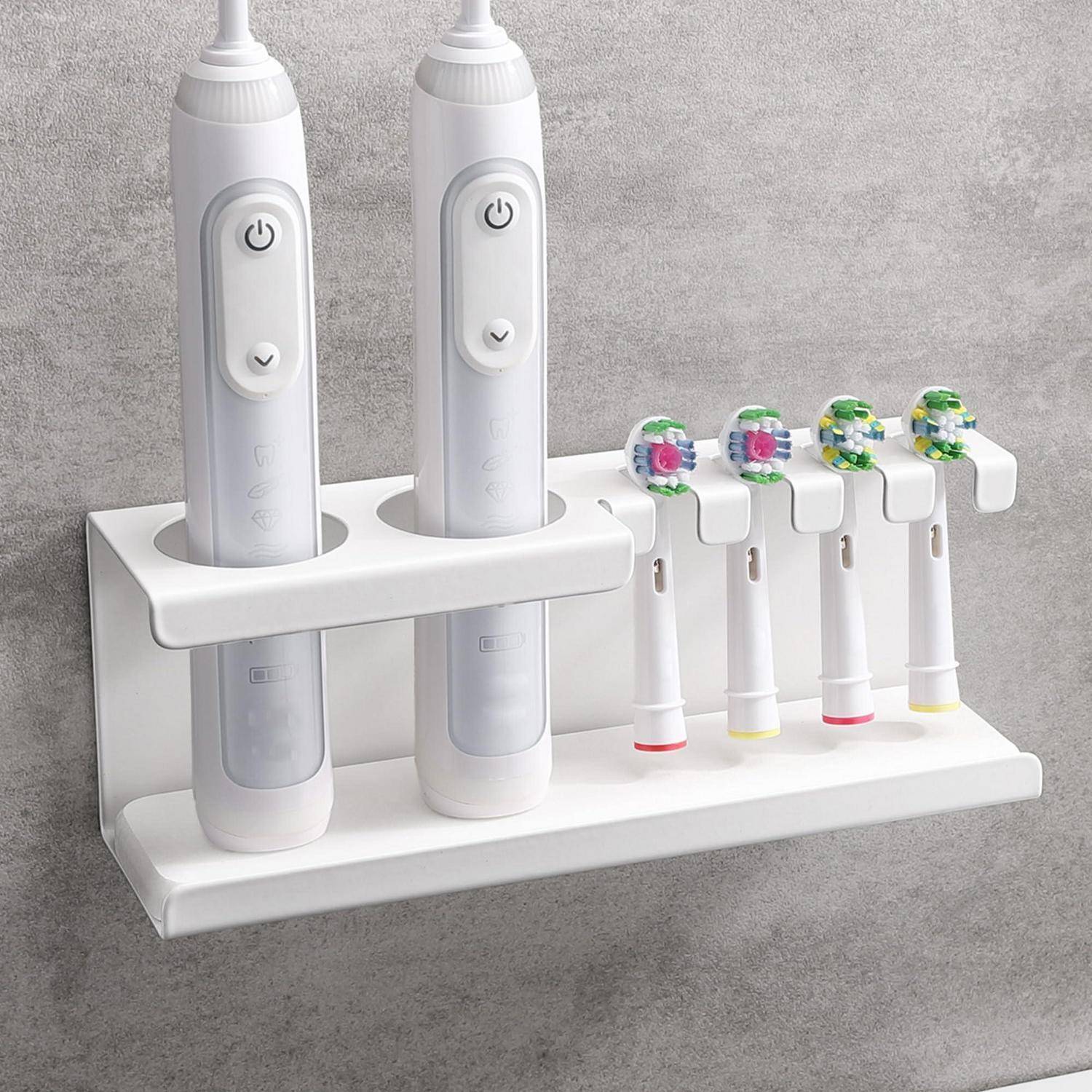 An der Wand montierte weiße Ladestation, die zwei elektrische Zahnbürsten und vier Ersatzbürstenköpfe gegen eine graue Wand hält.