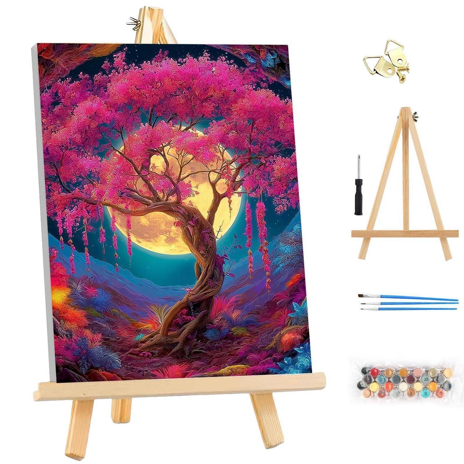 Bemalte Leinwand auf einer hölzernen Staffelei, die einen lebendigen rosa Baum vor einem leuchtenden Mond zeigt, mit einem Malkasten daneben.