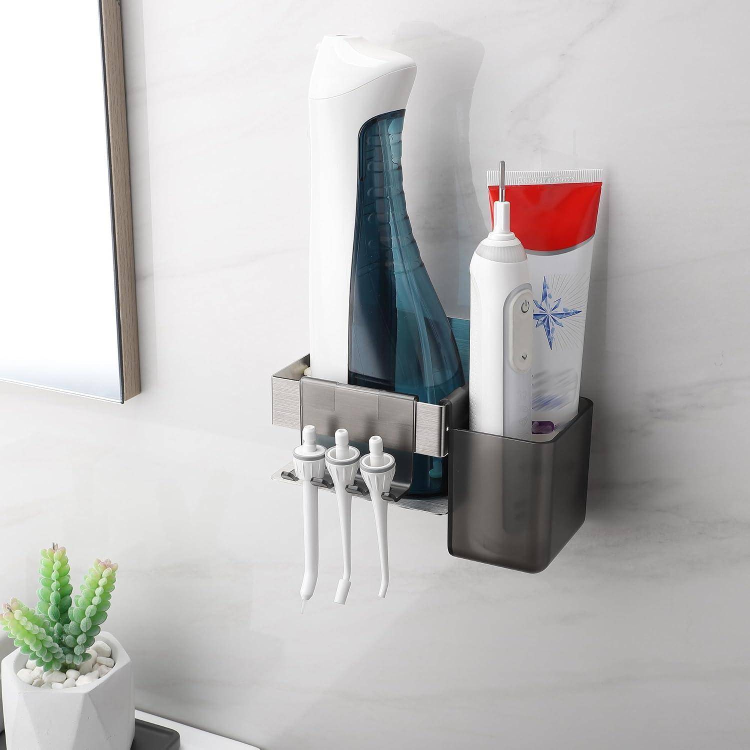 An der Wand montiertes Badezimmer-Regal mit einer Sprühflasche, einer Quetschtusche und Zahnpflegeinstrumenten, mit drei Zahnbürsten, die darunter hängen.