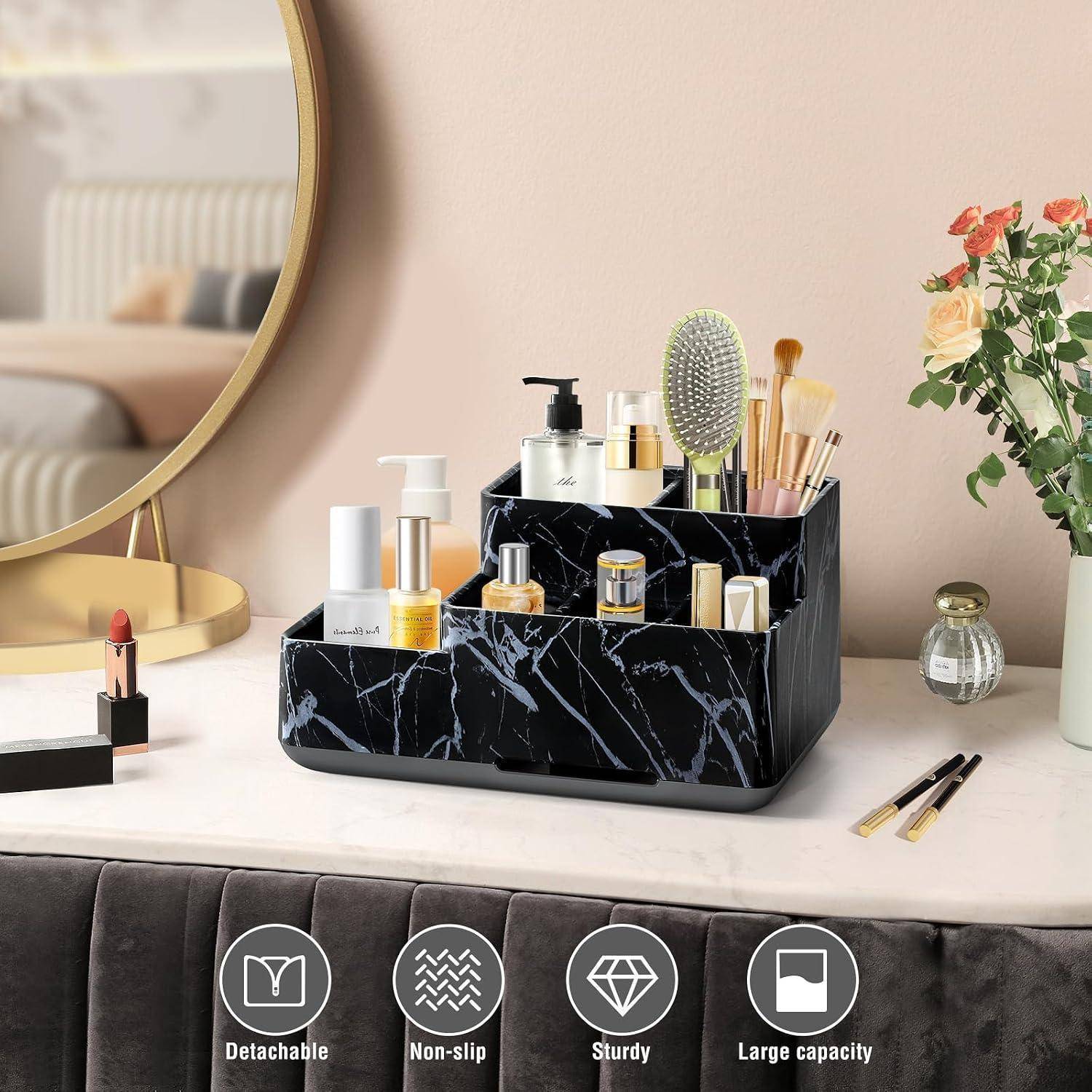 Schwarzer Organizer mit Marmor-Optik gefüllt mit Kosmetik und Pinseln auf einem Frisiertisch, mit Symbolen, die abnehmbar, rutschfest, robust und großvolumig zeigen.