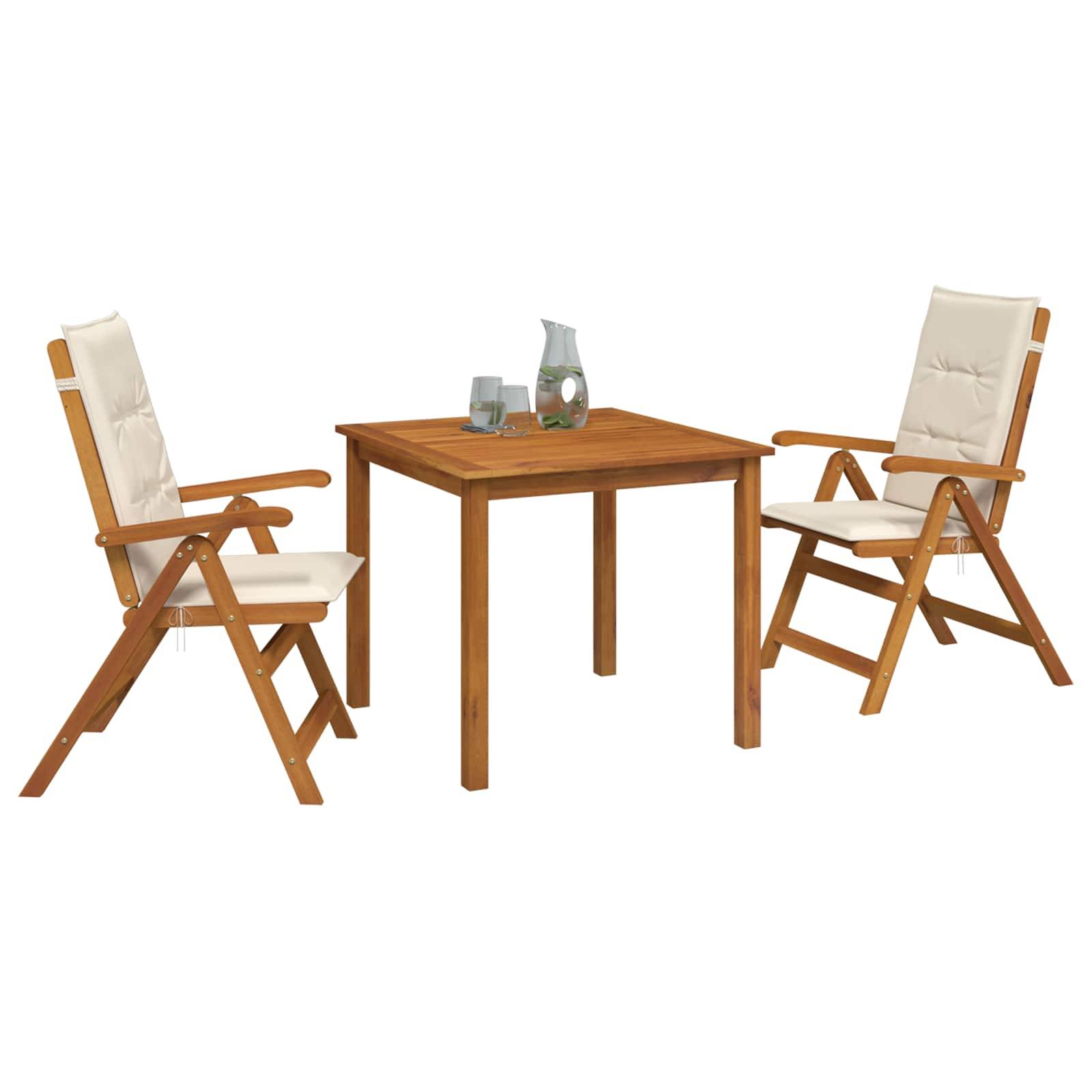 Zwei gepolsterte Holzklappstühle, die sich einem quadratischen Holztisch mit einem Glaskrug und Trinkgläsern auf der Oberseite zuwenden.