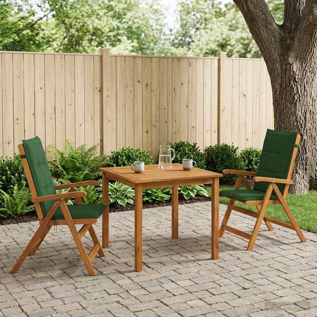 Gartenmöbelset im Freien mit zwei grünen Klappstühlen und einem Holztisch auf einer Backsteinterrasse neben einem Baum und einem Zaun, mit Tassen und einer Kanne auf dem Tisch.