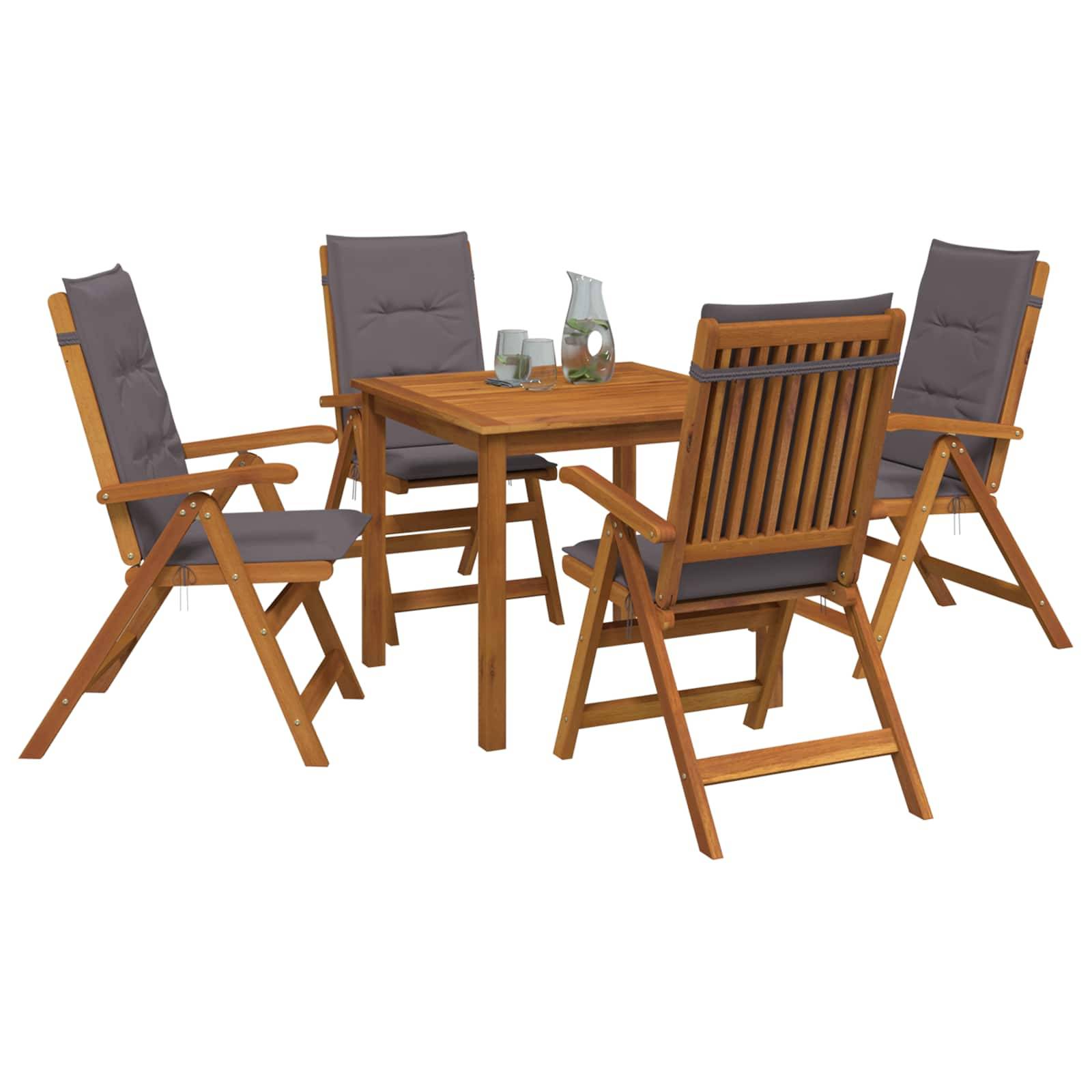 Vier Holzgartenstühle umgeben einen kleinen quadratischen Tisch mit Kissen, einem Glas und einer Kanne auf weißem Hintergrund.