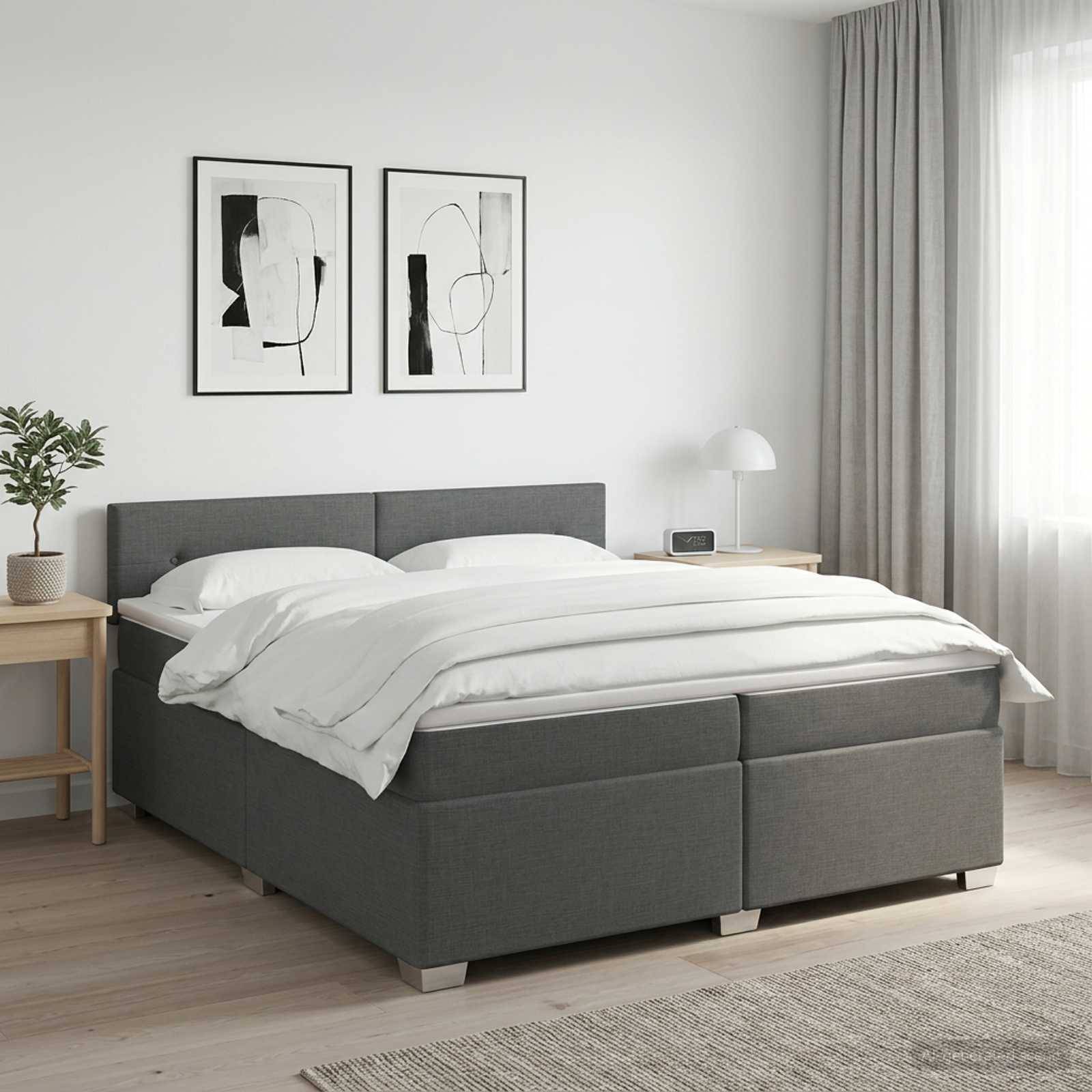 Modernes Schlafzimmer mit einem grauen Polsterbett, weißer Bettwäsche, Nachttischen, gerahmten Wandbildern und weichem Naturlicht aus einem Fenster.