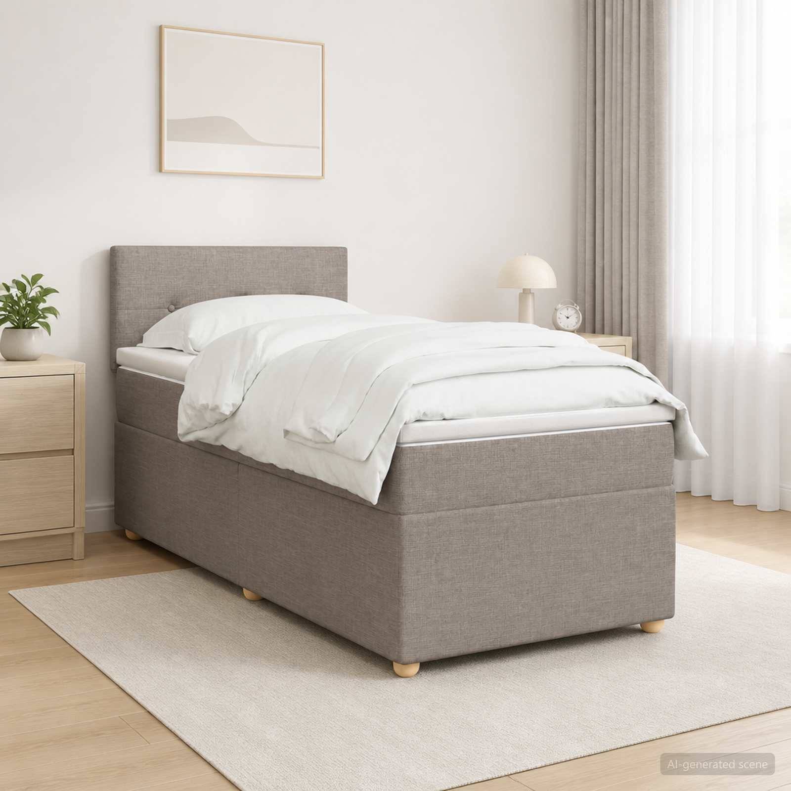 Minimales Schlafzimmer mit einem grau gepolsterten Bett, weißer Bettwäsche, Nachttisch, Lampe, Pflanze und gerahmter Wandkunst auf einem hellen Teppich.