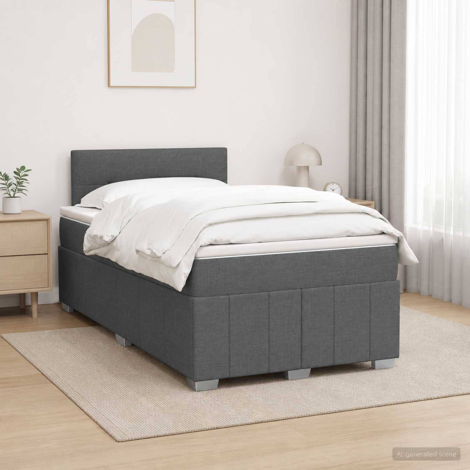 Grau gepolstertes Bett mit weißer Bettwäsche in einem hellen, minimalistischen Schlafzimmer, gezeigt auf einem beigen Teppich neben einem Nachttisch und einer Lampe.