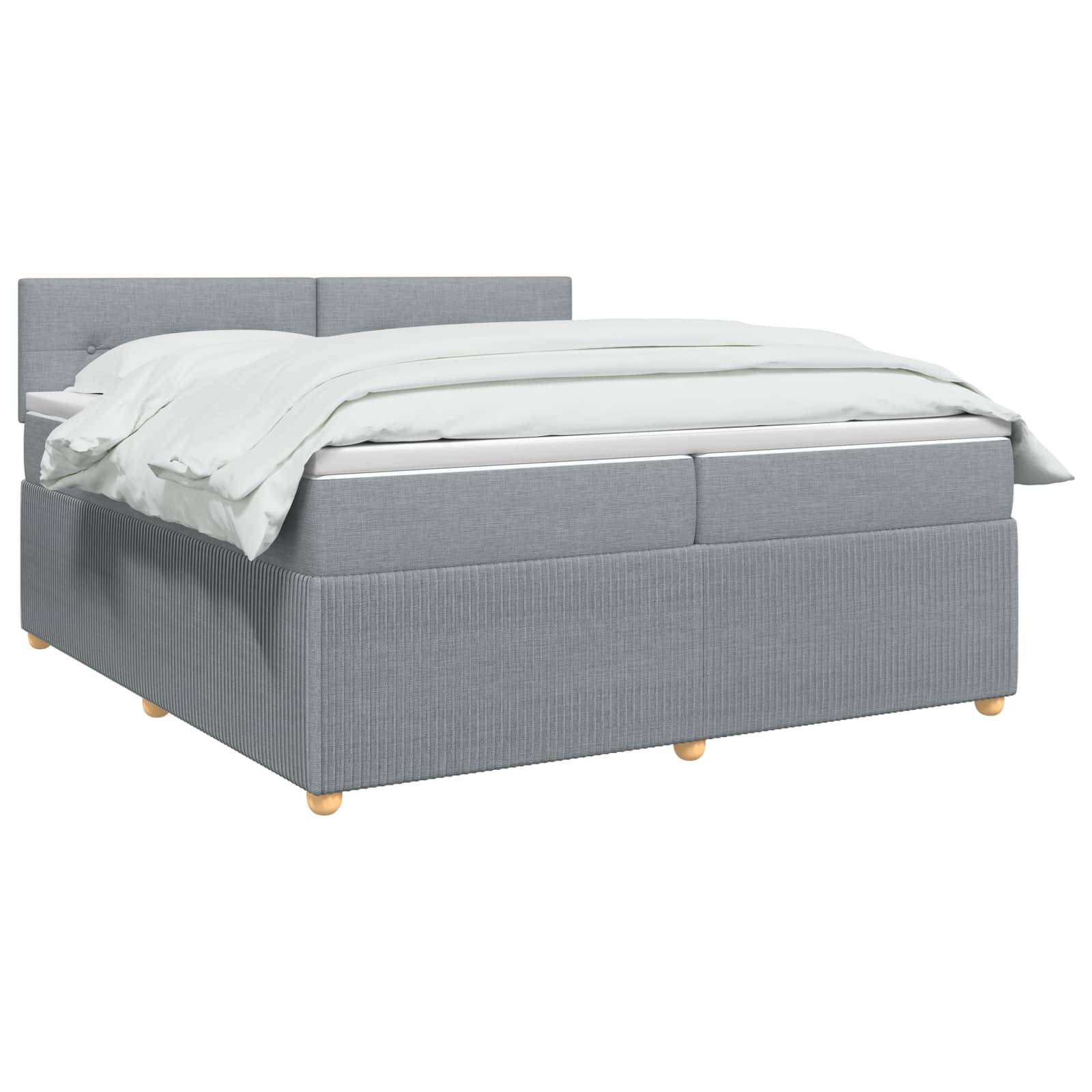 Graupolstertes Doppelbett mit Kopfteil, weiße Bettwäsche und Holzfüße auf einfarbig weißem Hintergrund.