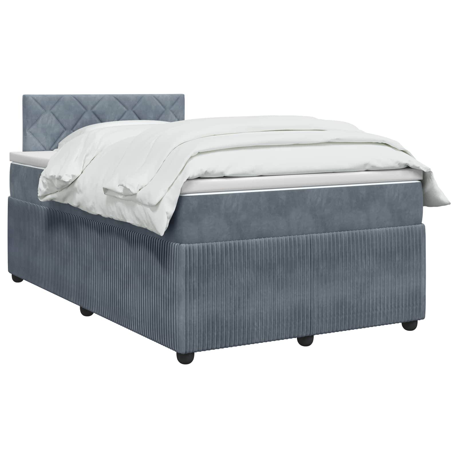 Ein grau gepolstertes Bett mit gestepptem Kopfteil, weißer Bettwäsche und einer Basis im Lagerstil auf kleinen schwarzen Füßen.