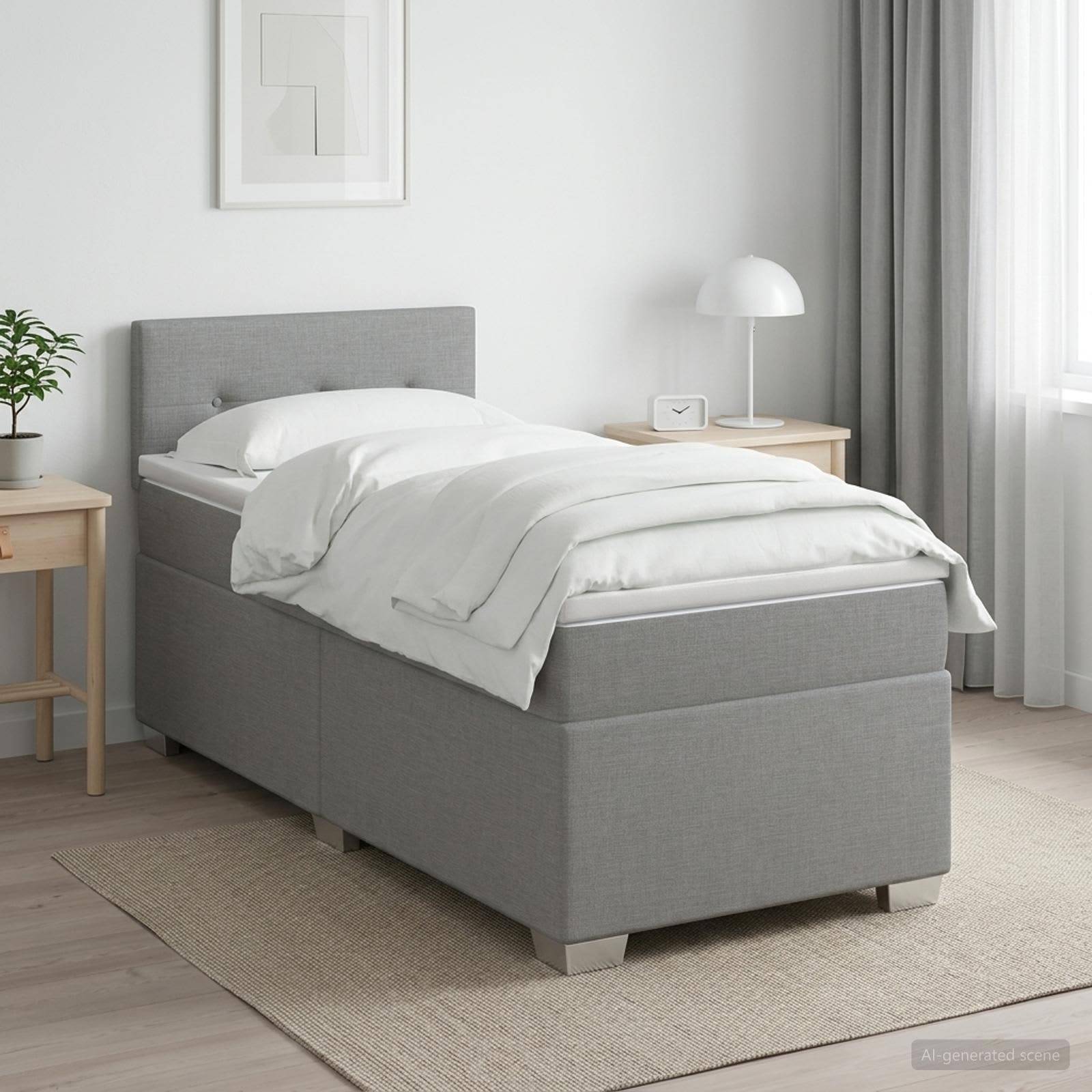 Ein ordentlich gemachtes Einzelbett mit grauer gepolsterter Basis und Kopfteil in einem hellen, minimalistischen Schlafzimmer, flankiert von Nachttischen und einer Lampe.