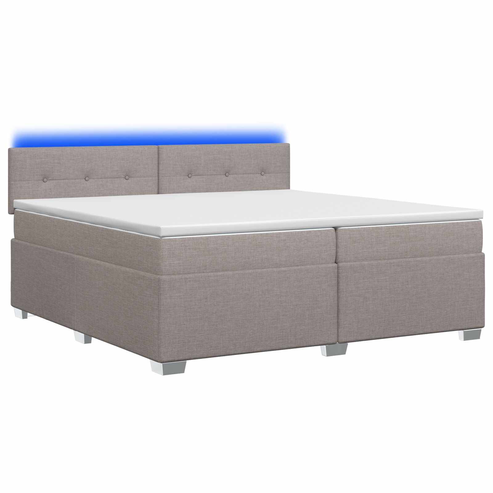 Grau gepolstertes Bett mit kapitoniertem Kopfteil und weißer Matratze auf einem einfachen weißen Hintergrund.