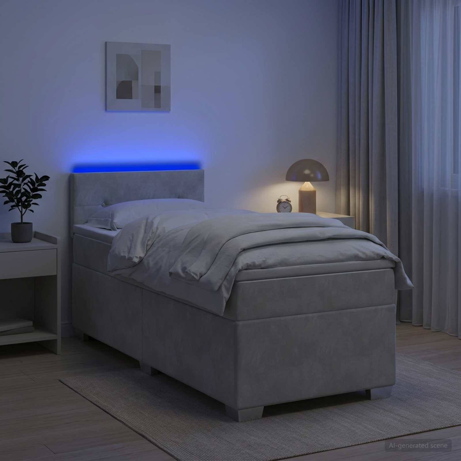 Ein ordentlich gemachtes grau gepolstertes Bett in einem sanft beleuchteten Schlafzimmer mit leuchtendem blauem Kopfteil, Nachttischlampe, Pflanze und Vorhängen.