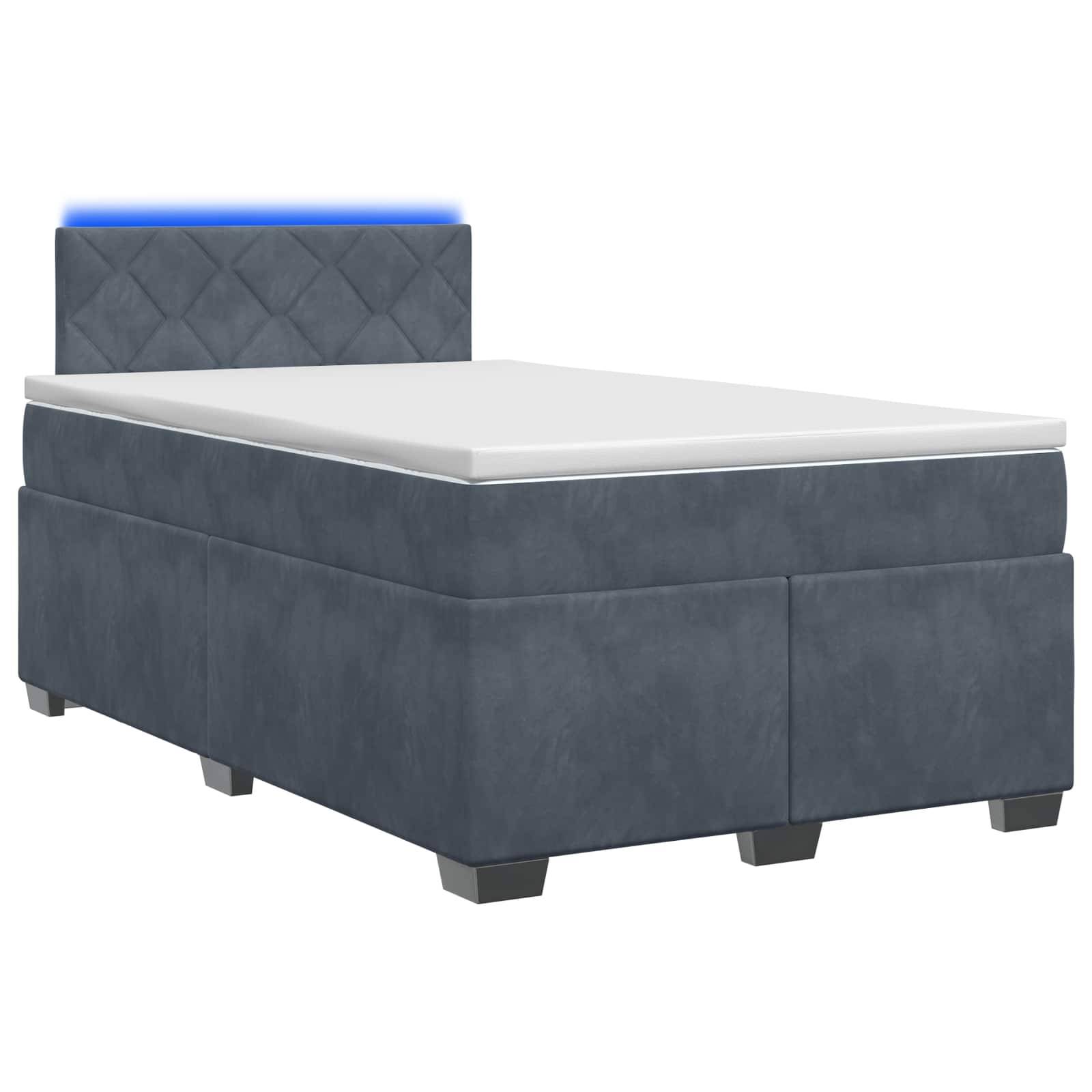 Blaues Einzelbett mit Polsterung, gepolstertem Kopfteil und weißer Matratze auf neutralem Hintergrund.
