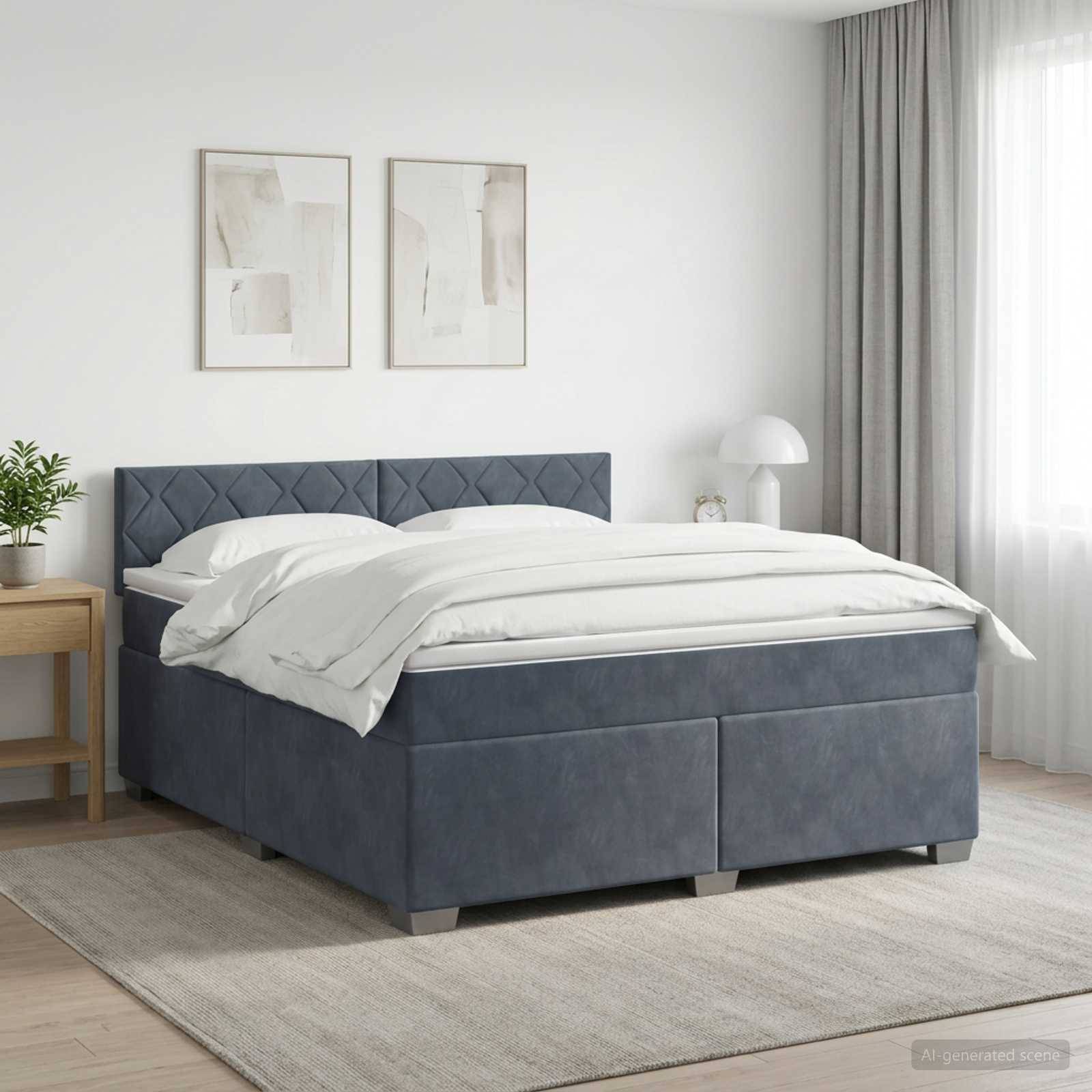 Ein ordentlich gemachtes grau gepolstertes Bett in einem hellen, minimalistischen Schlafzimmer mit weißer Bettwäsche, gerahmten Wandbildern, einem Nachttisch, einer Lampe und transparenten Gardinen.