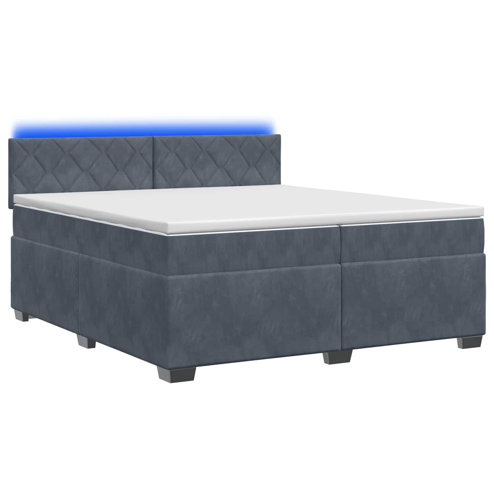 Grau gepolstertes Speicherbett mit weißer Matratze und gepolstertem gestepptem Kopfteil, beleuchtet durch einen blauen LED-Streifen, auf weißem Hintergrund abgebildet.