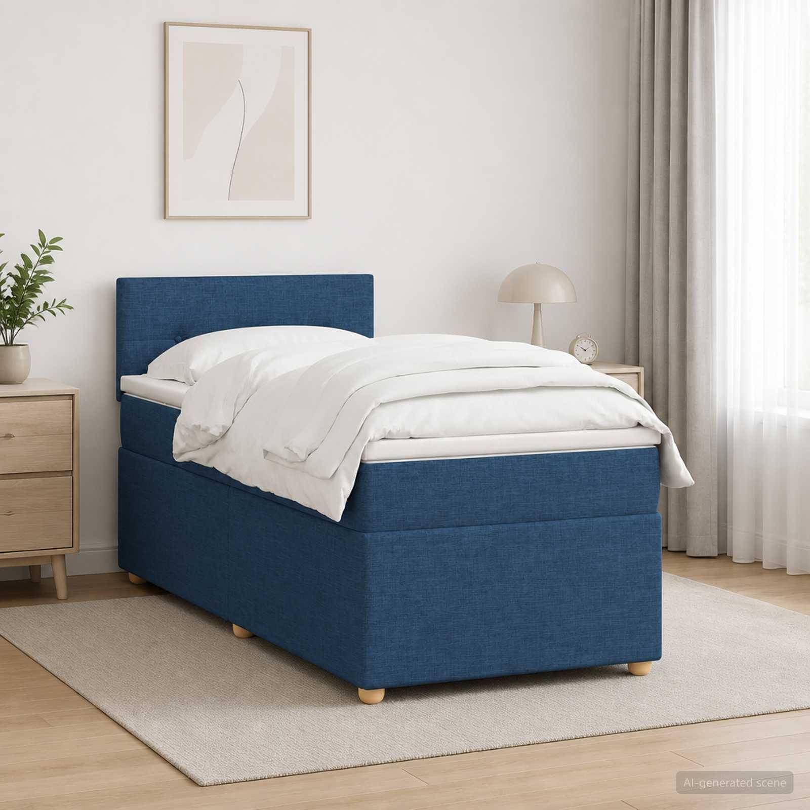 Blaugepolstertes Einzelbett mit weißer Bettwäsche in einem minimalistischen Schlafzimmer neben einem Nachttisch und einer Lampe, auf einem hellen Teppich neben einem Fenster.
