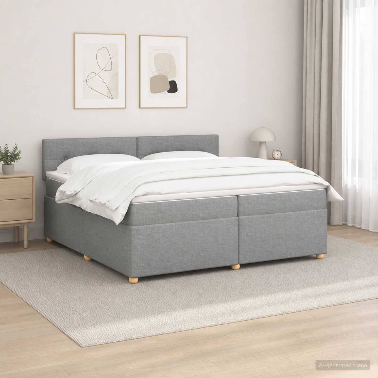 Ein grau gepolstertes Bett mit weißer Bettwäsche in einem hellen, minimalistischen Schlafzimmer, gezeigt mit gerahmter Wandkunst, Nachttisch, Lampe und Teppich.