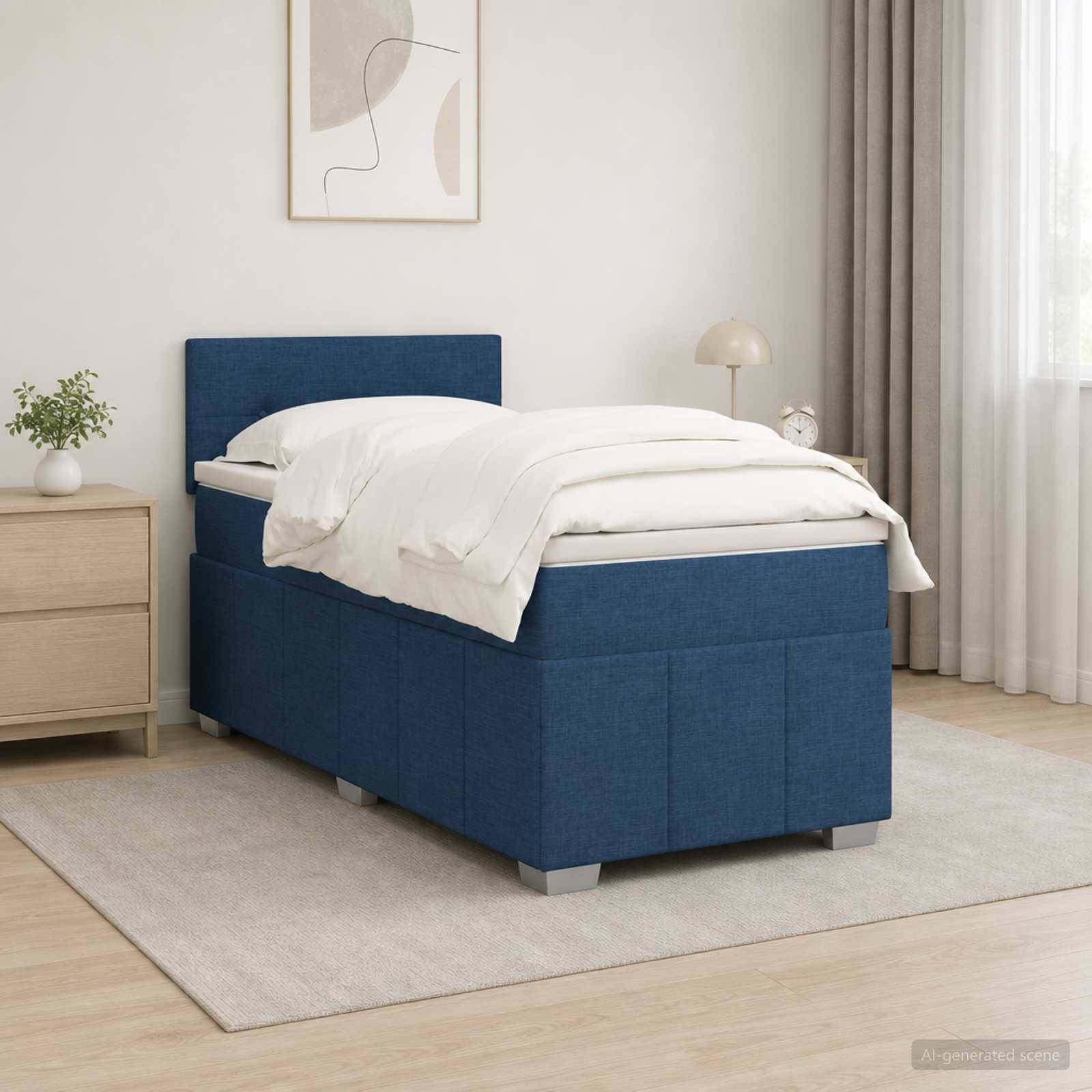 Bett mit blauem Polsterstoff im Einzelbettformat mit weißer Bettwäsche in einem minimalistischen Schlafzimmer neben einem Nachttisch und Vorhängen am Fenster.