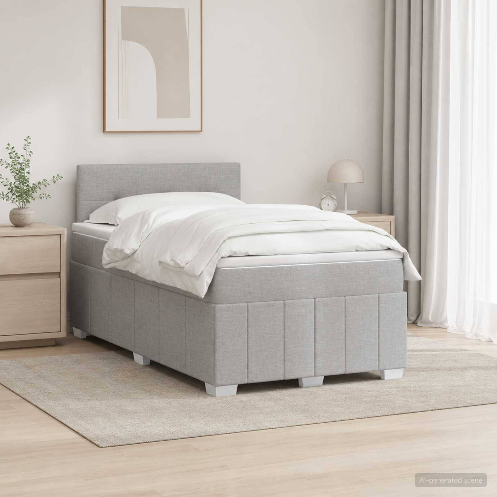 Modernes Schlafzimmer mit einem grau gepolsterten Einzelbett, weißer Bettwäsche, Nachttischen, Lampe und gerahmter Wandkunst auf einem hellen Teppich.