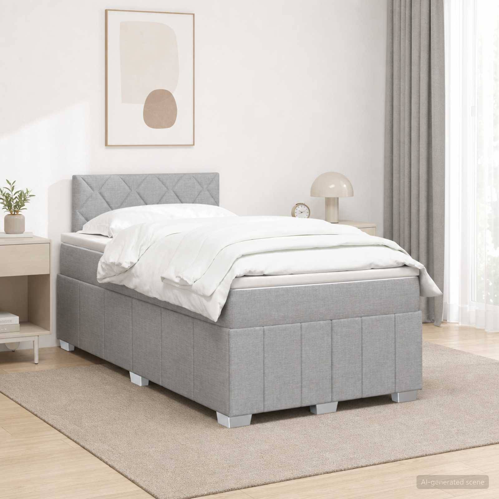 Ein graues gepolstertes Einzelbett mit weißer Bettwäsche in einem minimalistischen Schlafzimmer, neben einem Nachttisch und einer Lampe mit Vorhängen und Wandkunst.