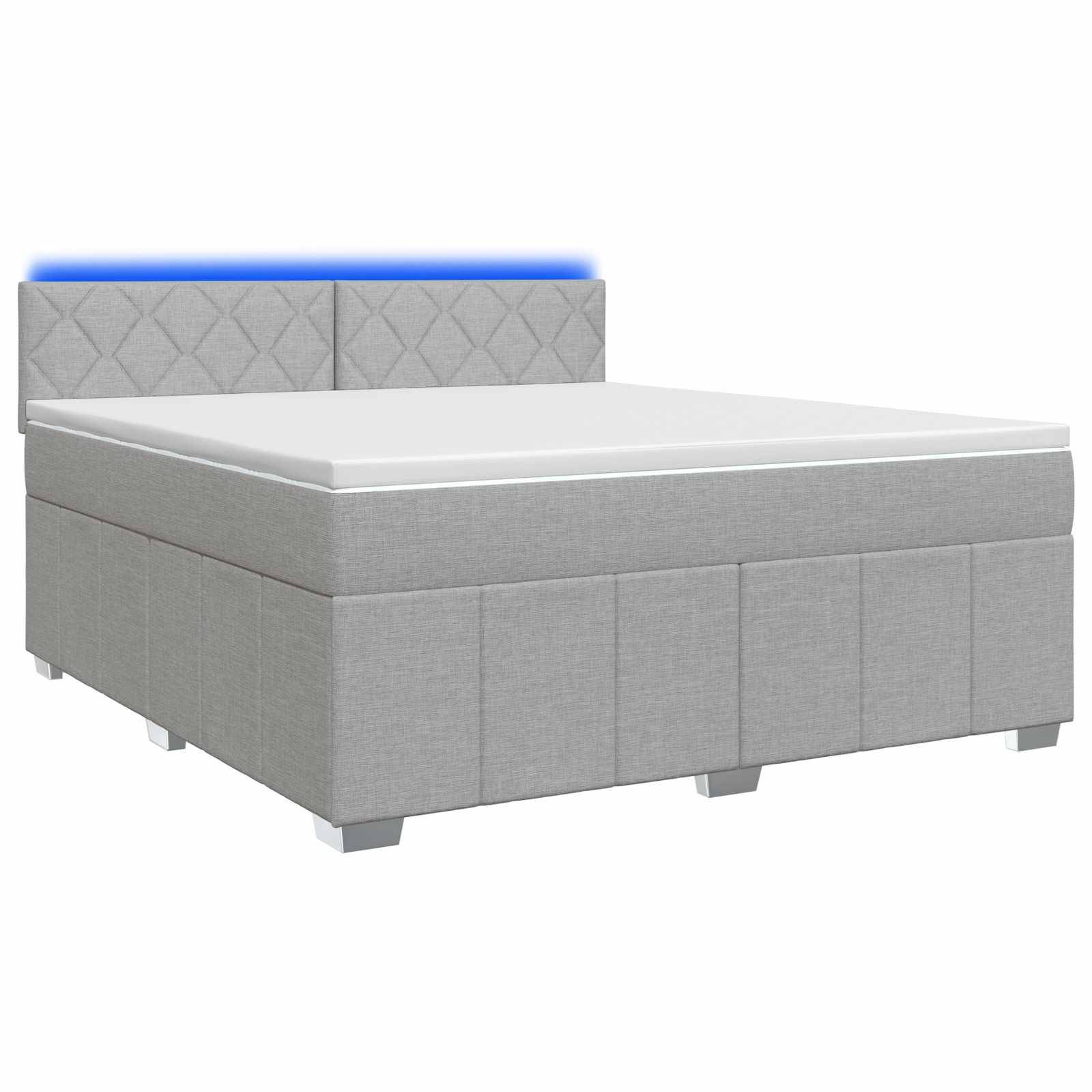 Grau gepolstertes Bett mit weißer Matratze und gepolstertem Kopfteil mit Diamant-Steppung, gezeigt auf einfachem weißem Hintergrund.