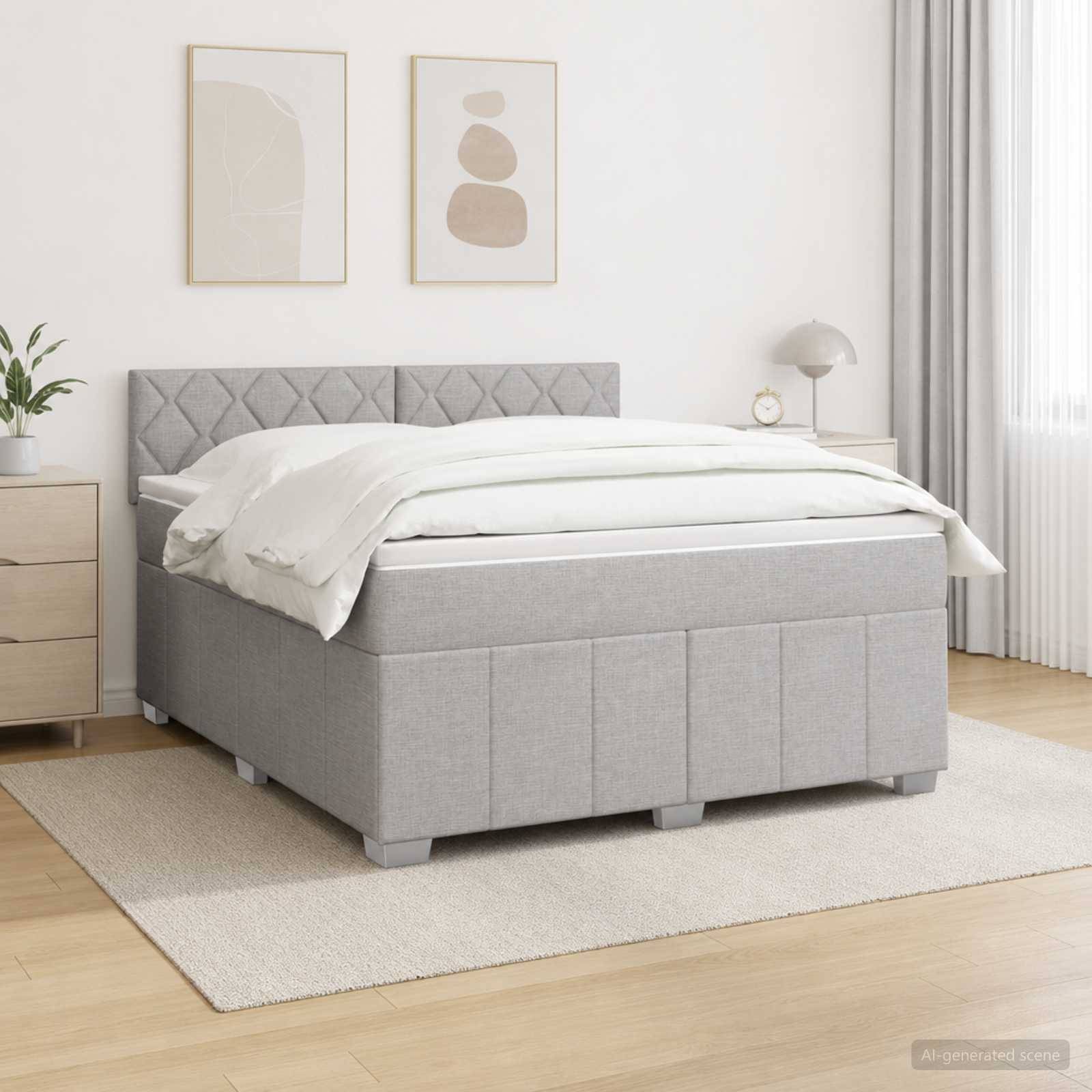Grau gepolstertes Bett mit gestepptem Kopfteil und weißer Bettwäsche in einem hellen, minimalistischen Schlafzimmer, gezeigt mit passendem Nachttisch, Lampe, Pflanze und gerahmtem Wandbild.