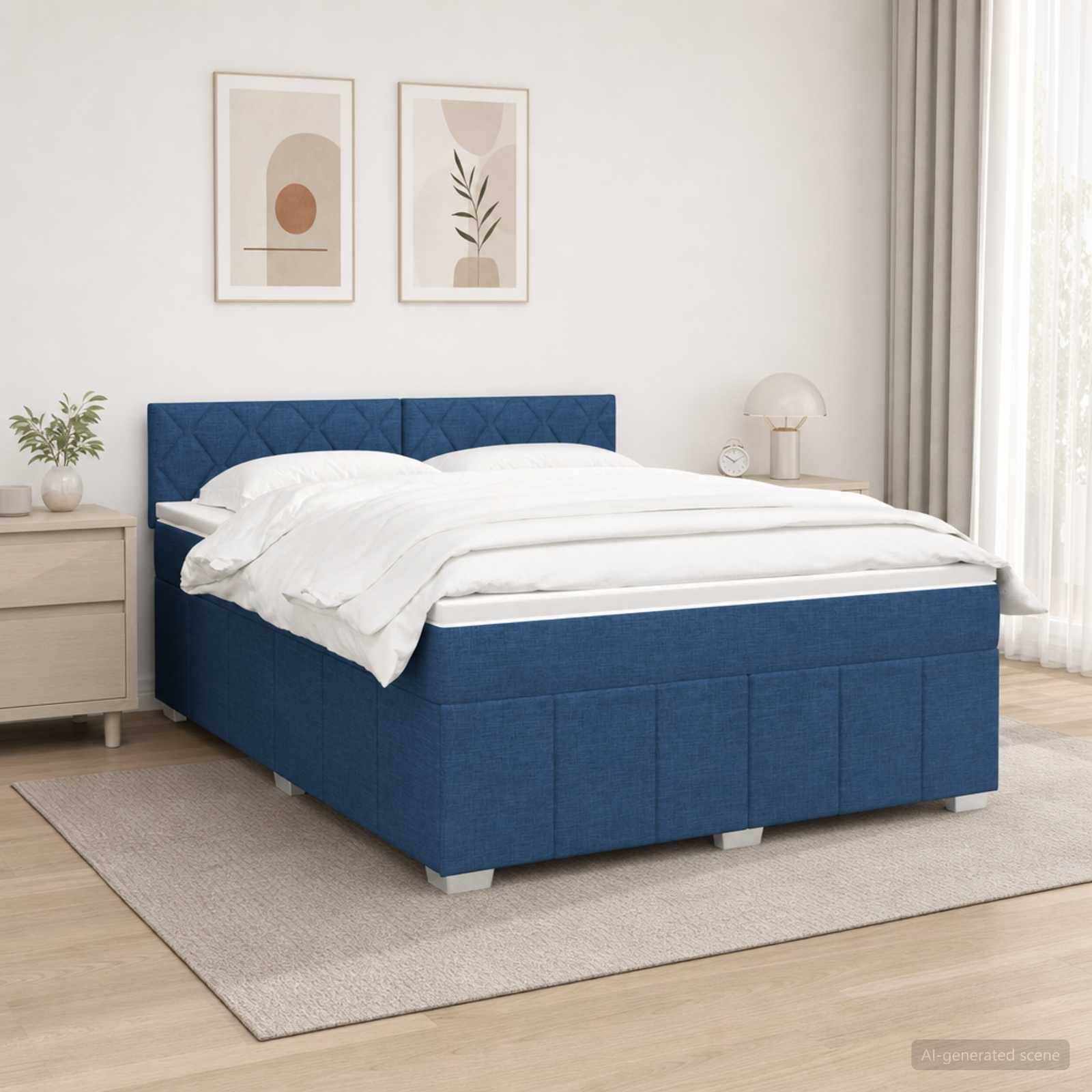 Bett mit blauem Polsterstoff und weißer Bettwäsche in einem hellen, minimalistischen Schlafzimmer mit gerahmten Wandbildern und einem Nachttisch