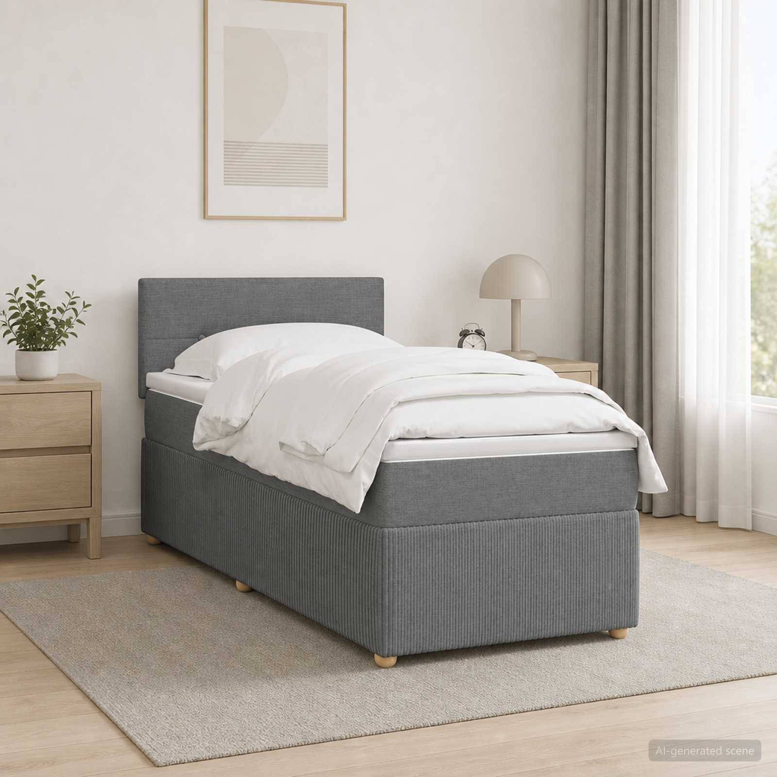 Ein ordentlich gemachtes, grau gepolstertes Einzelbett in einem minimalistischen Schlafzimmer mit weißer Bettwäsche, Nachttisch, Lampe, Pflanze und gerahmter Wandkunst.
