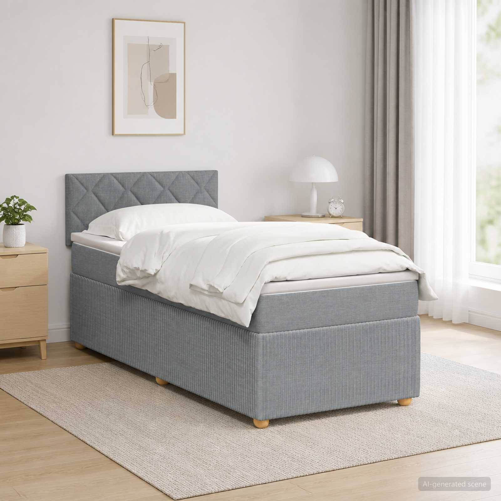 Ein ordentlich gemachtes grau gepolstertes Einzelbett in einem hellen minimalistischen Schlafzimmer mit Nachttischen, Lampe, gerahmten Wandbildern, Vorhängen und einem Teppich.