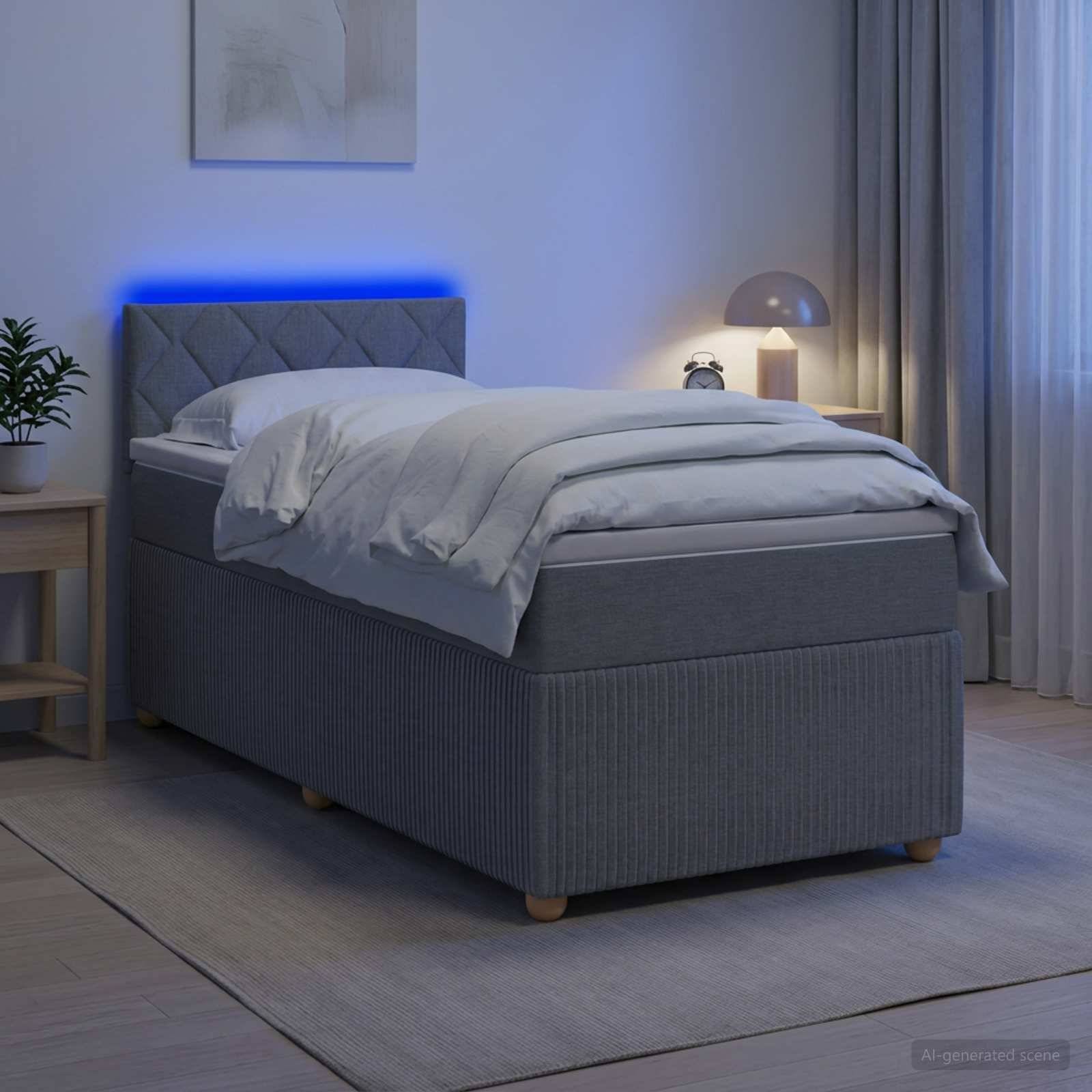 Modernes grau gepolstertes Bett mit blauer LED-Kopfleuchtenbeleuchtung in einem sanft beleuchteten Schlafzimmer, ausgestattet mit weißer Bettwäsche und flankiert von einem Nachttisch und einer Lampe.