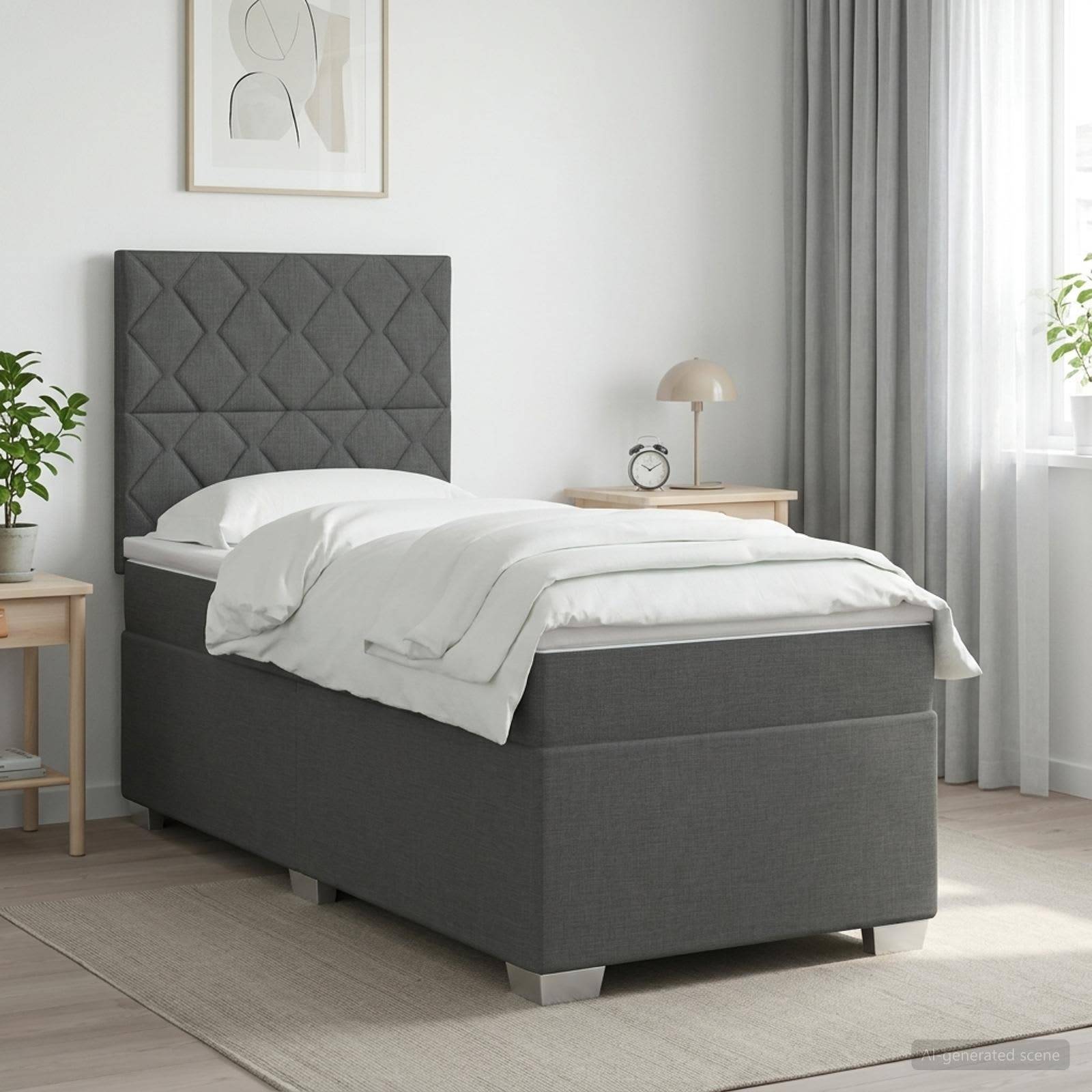 Grau gepolstertes Einzelbett mit gestepptem Kopfteil und weißer Bettwäsche in einem hellen, minimalistischen Schlafzimmer.