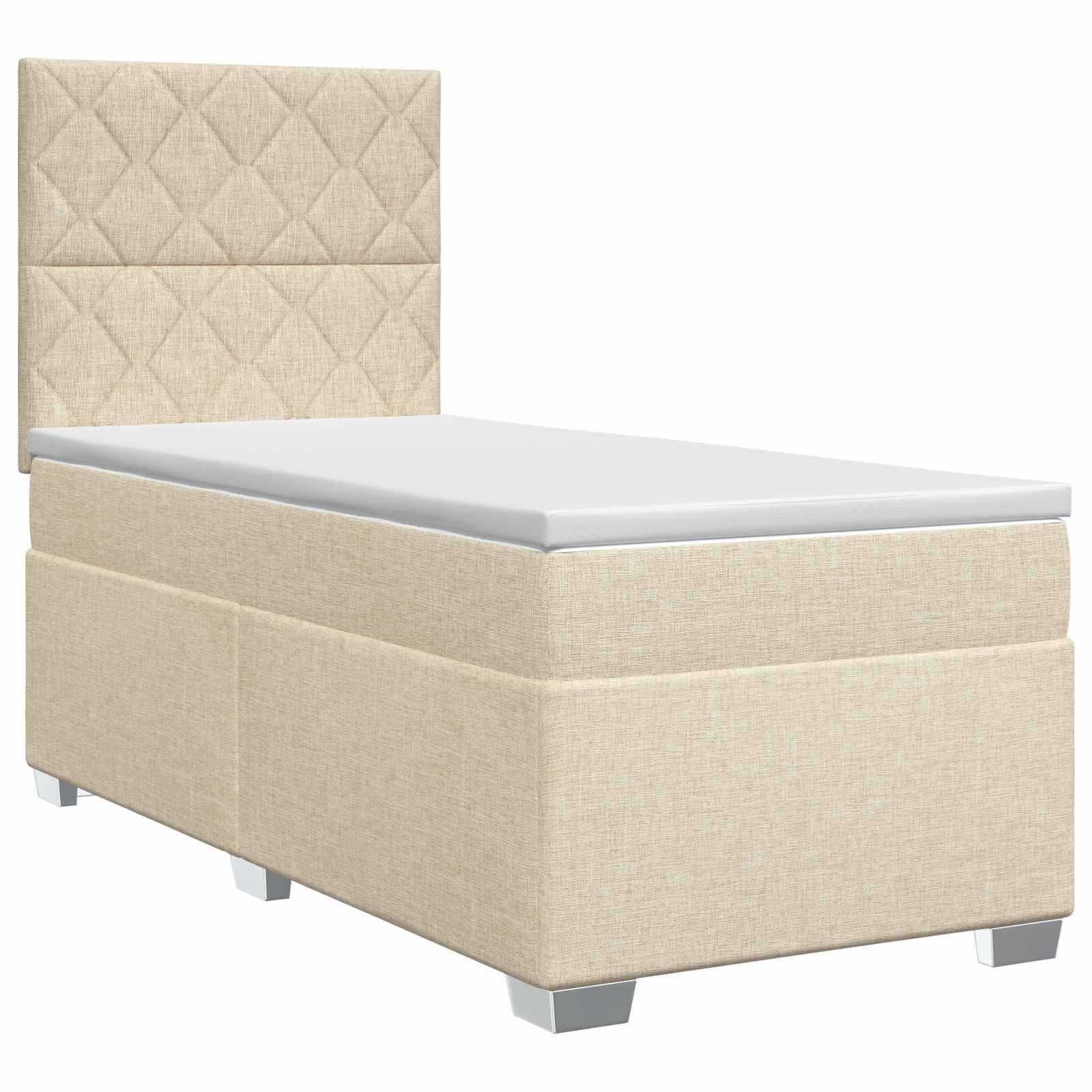 Beige gepolstertes Einzelbett mit gestepptem Kopfteil und weißer Matratze auf kurzen silbernen Füßen.