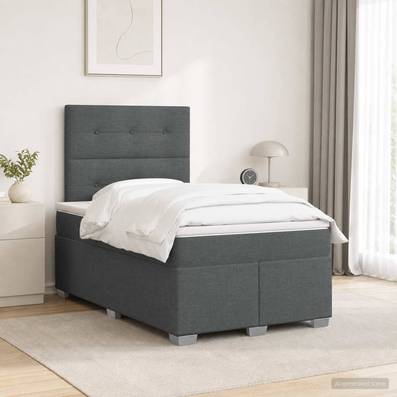 Ein ordentlich gemachtes grau gepolstertes Einzelbett in einem hellen, minimalistischen Schlafzimmer mit weißer Bettwäsche, Nachttisch, Lampe, Pflanze und Teppich.