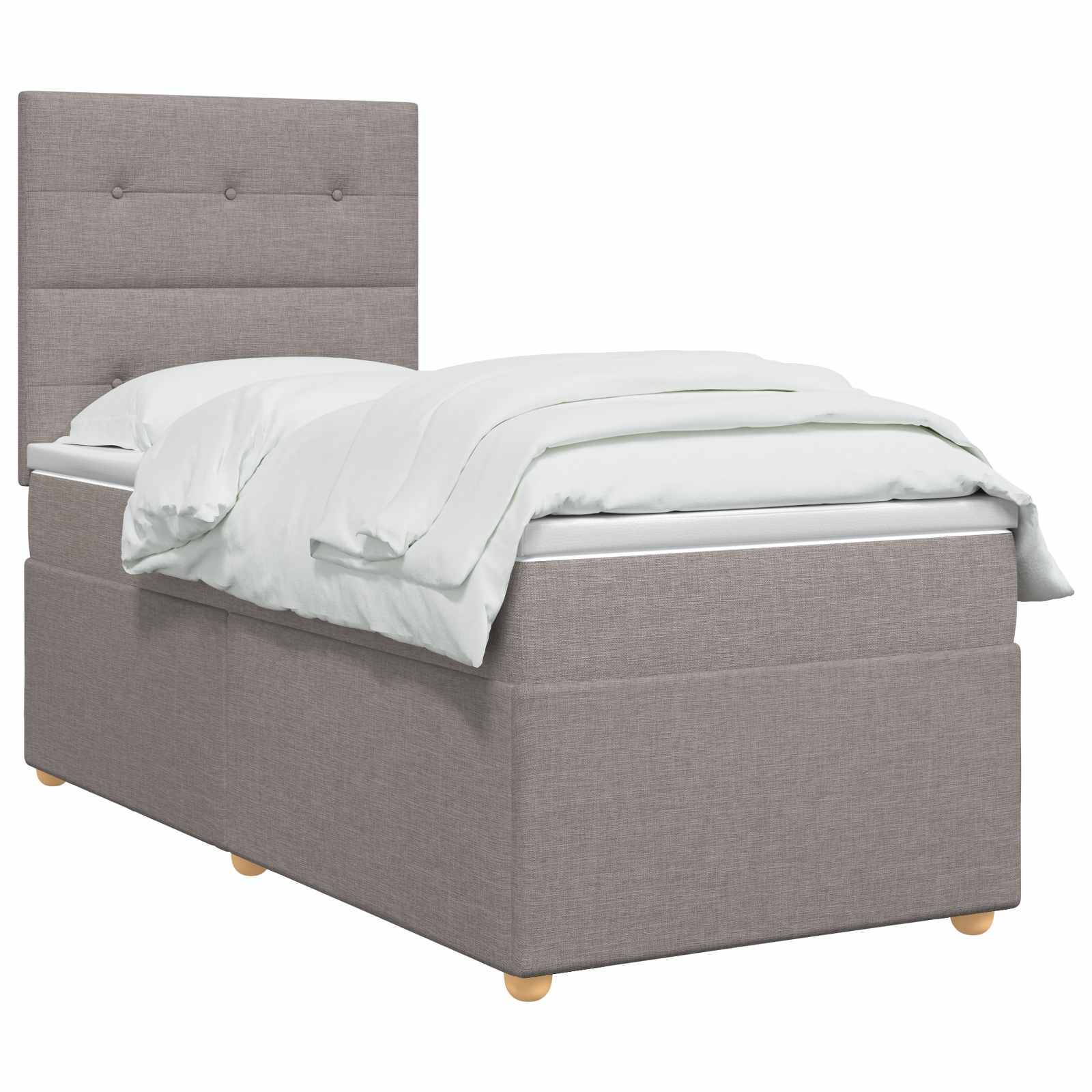 Einzelnes gepolstertes graues Bett mit gestepptem Kopfteil, weißer Bettwäsche und Holzfüßen auf weißem Hintergrund.