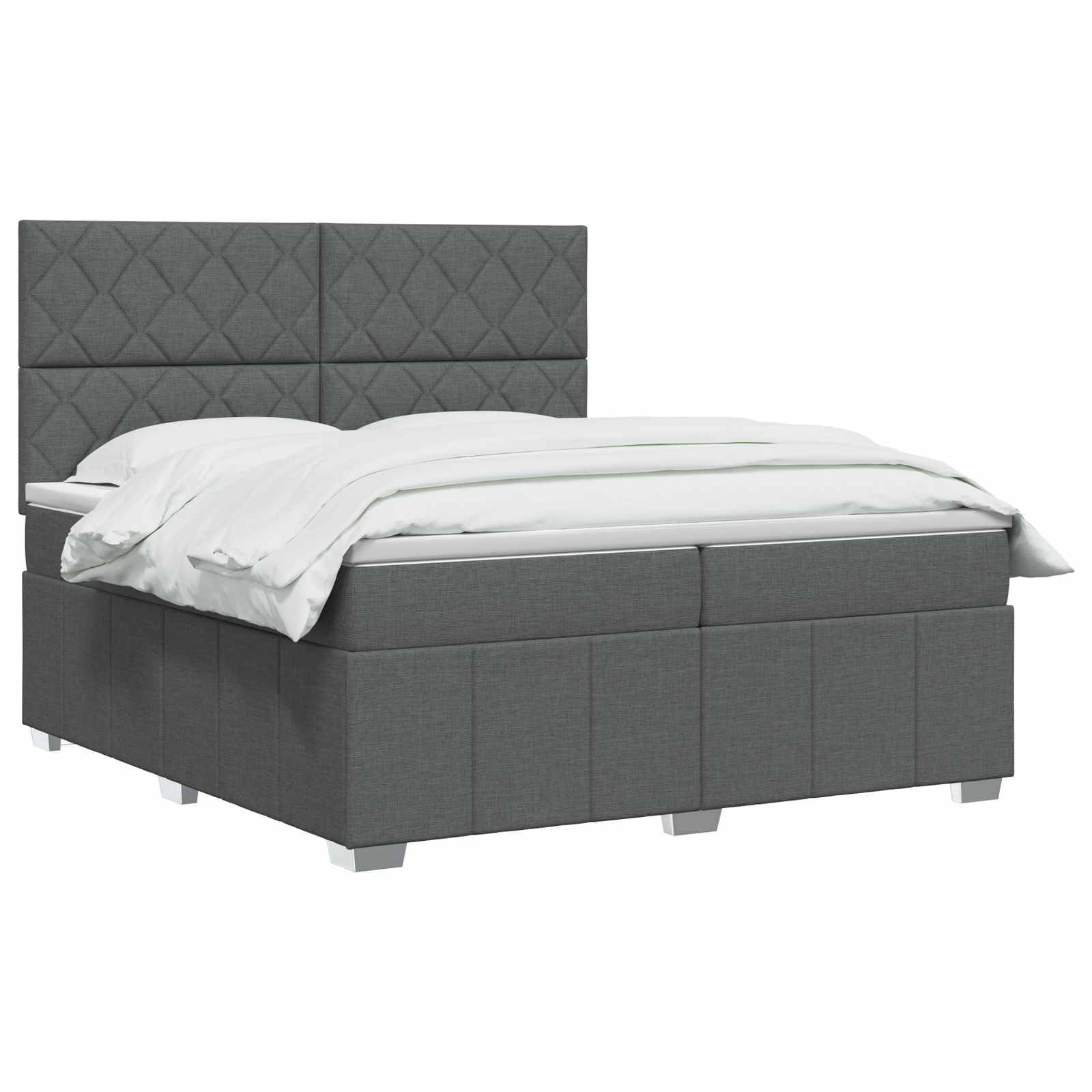 Graues gepolstertes Bett mit diamantgestepptem Kopfteil und weißer Bettwäsche auf einfachem Studiohintergrund.