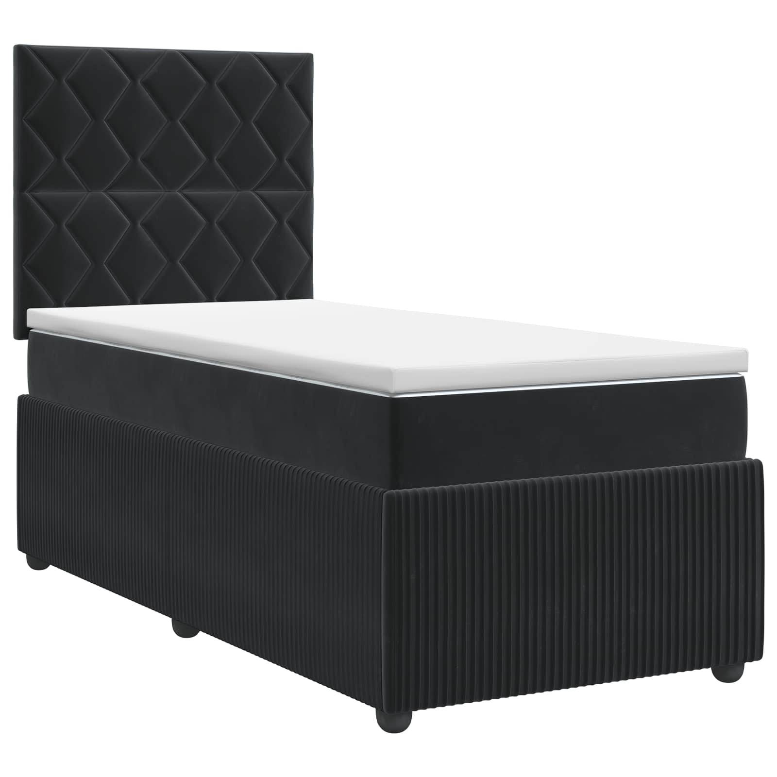 Schwarzes Einzelbett mit Polsterung und gestepptem Kopfteil mit Diamantmuster sowie weiße Matratze vor einem neutralen Hintergrund.