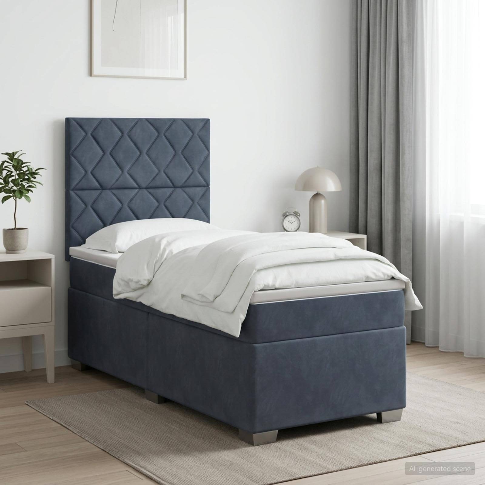 Blaues Polstereinfachbett mit gestepptem Kopfteil in einem hellen modernen Schlafzimmer, ausgestattet mit weißer Bettwäsche neben einem Nachttisch und einer Lampe.