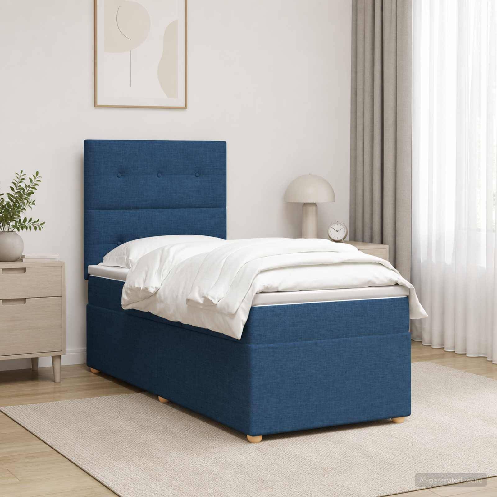 Ein blaugepolstertes Einzelbett in einem hellen Schlafzimmer, ausgestattet mit weißer Bettwäsche und einem hohen Kopfteil neben einem Nachttisch und einer Lampe.