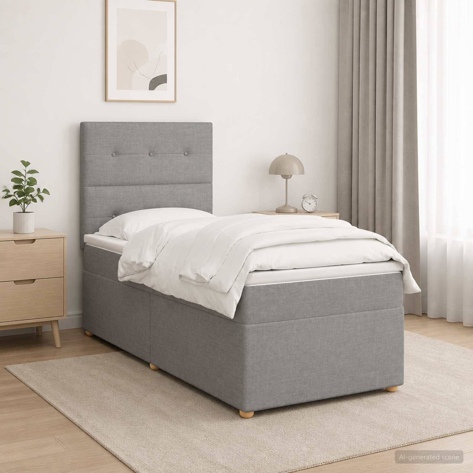 Ein ordentlich gemachtes grau gepolstertes Einzelbett in einem minimalistischen Schlafzimmer mit weißer Bettwäsche, Nachttisch, Lampe, Pflanze und durchsichtigen Vorhängen.