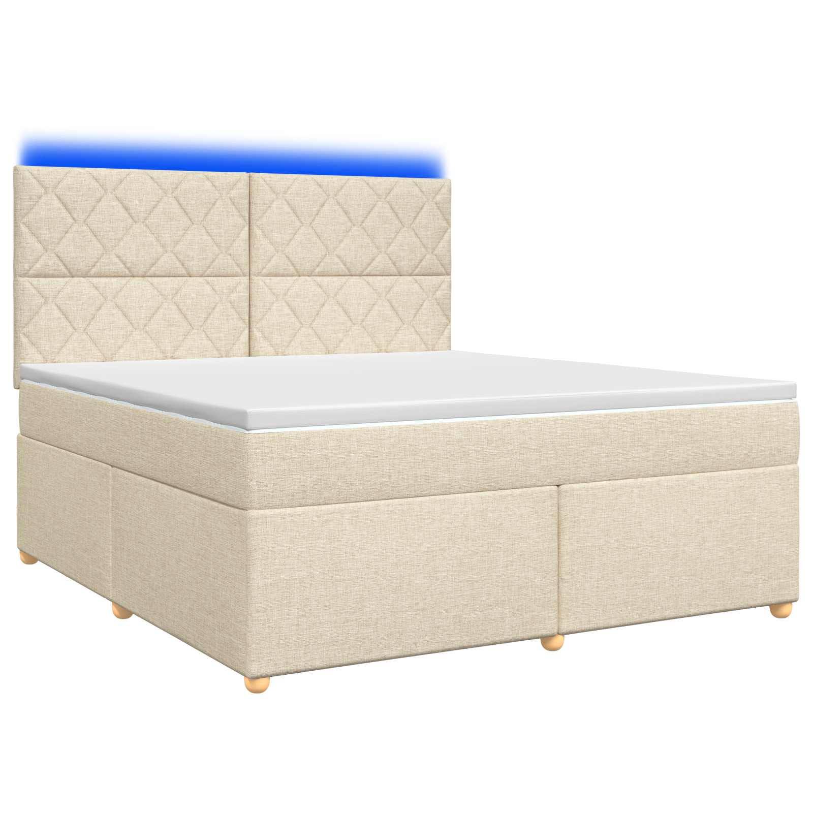 Beige gepolstertes Bett mit gestepptem Kopfteil und passendem Untergestell, dargestellt mit einer weißen Matratze auf neutralem Hintergrund.