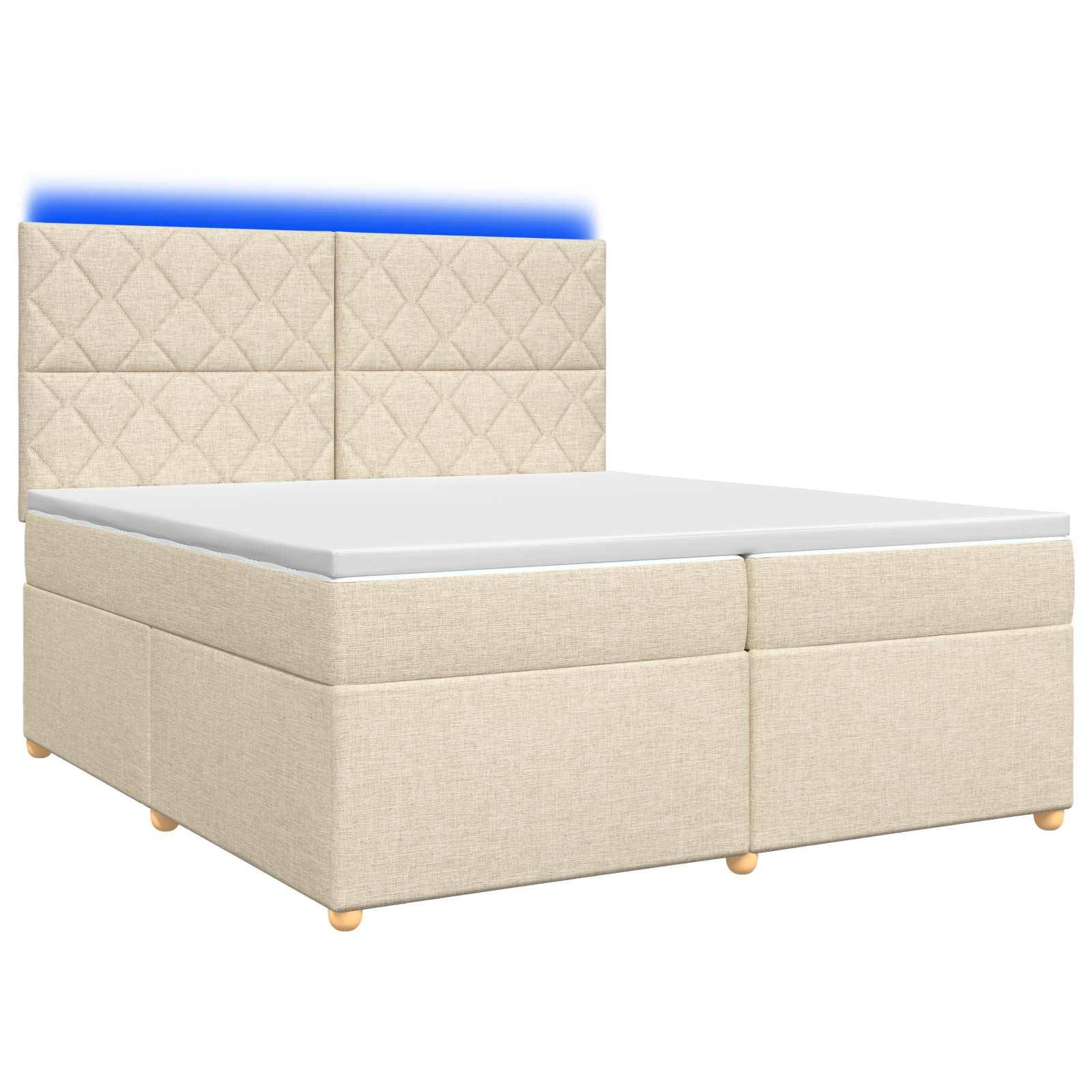 Beige gepolstertes Bett mit hohem gestepptem Kopfteil und weißer Matratze auf weißem Hintergrund.