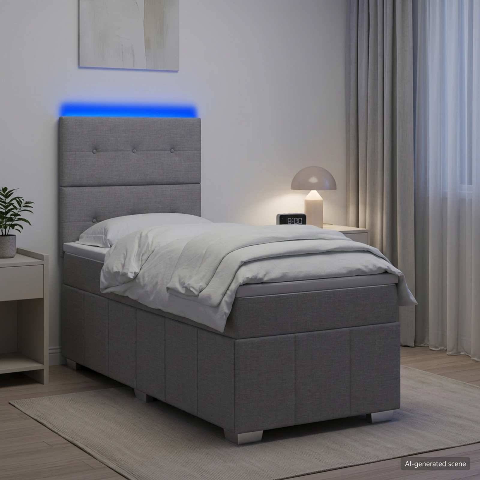 Modernes grau gepolstertes Bett in einem sanft beleuchteten Schlafzimmer mit blauer LED-Kopfleuchten-Beleuchtung, weißer Bettwäsche, Nachttischlampe und Gardinen.