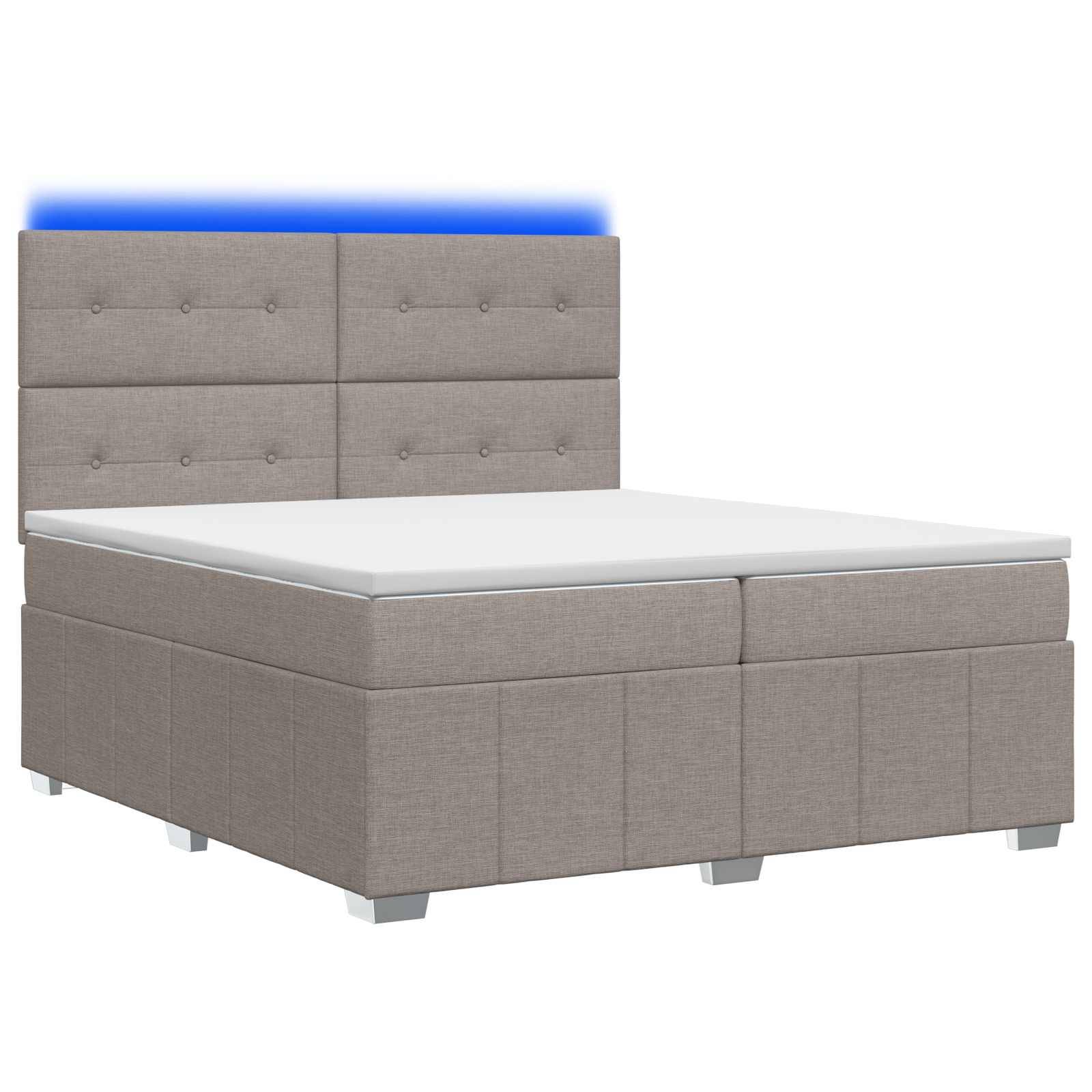 Grau gepolstertes Bett mit gestepptem Kopfteil und weißer Matratze auf weißem Hintergrund, mit blauem Licht, das hinter dem Kopfteil leuchtet.